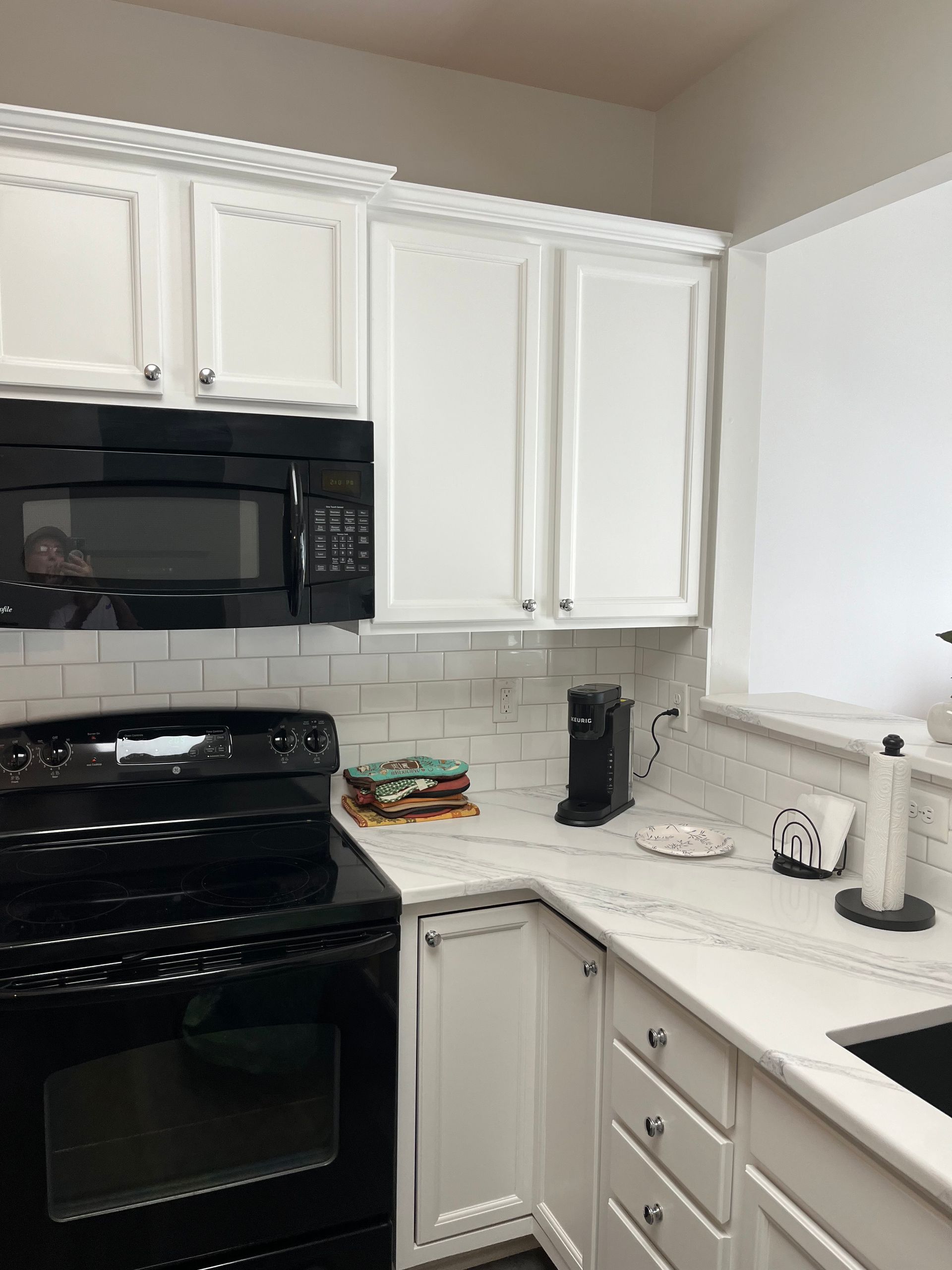 A kitchen with white cabinets and a black stove top oven