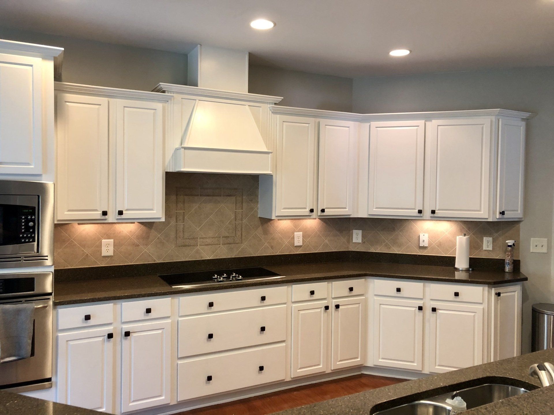 A kitchen with white cabinets and granite counter tops