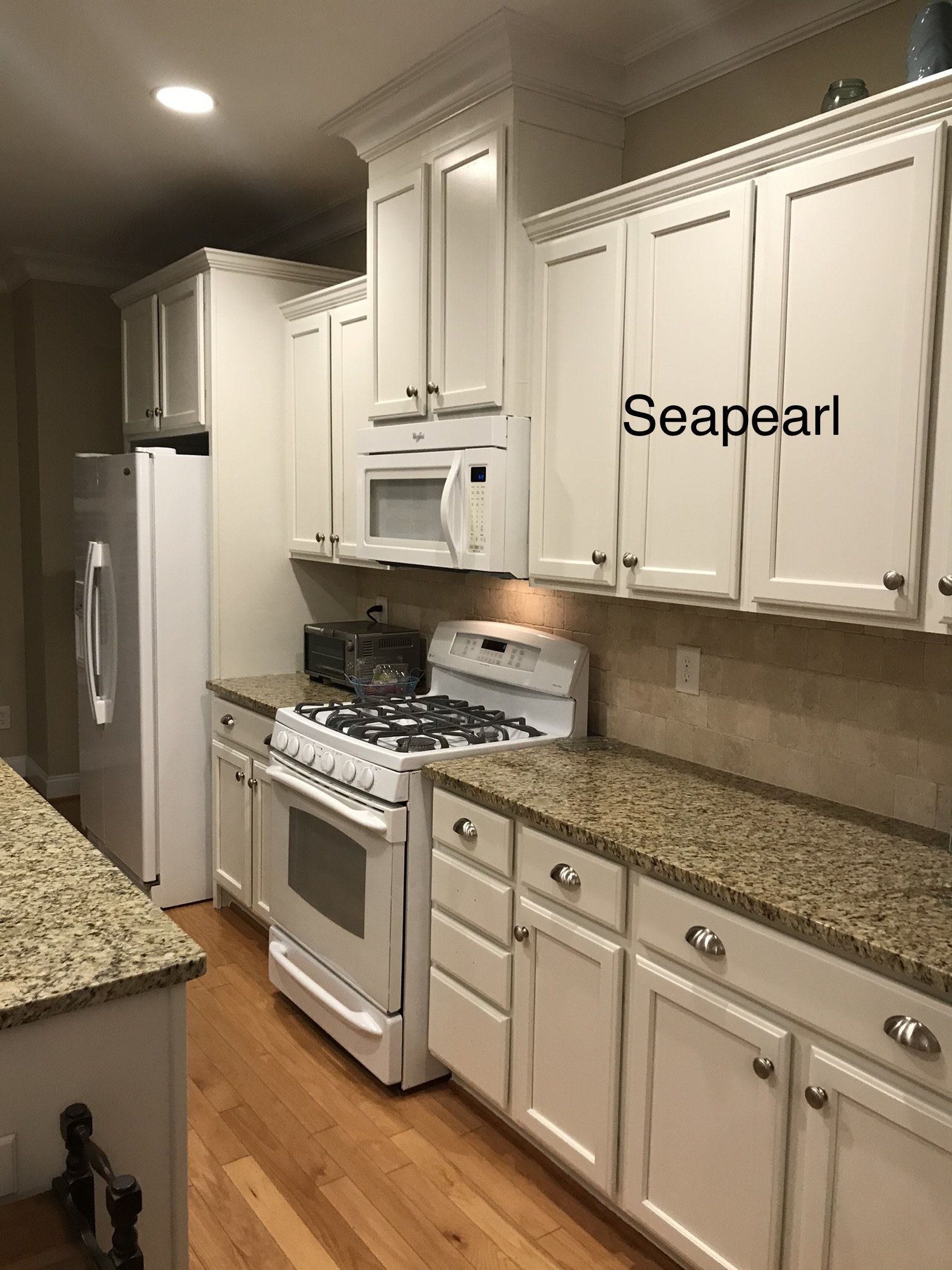 A kitchen with white cabinets and granite counter tops