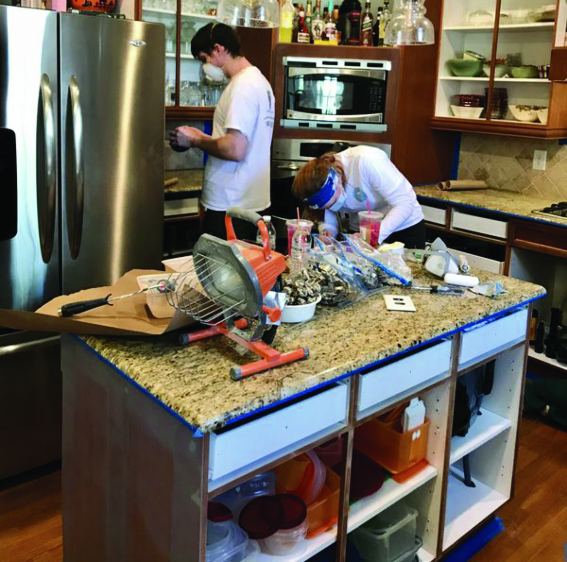 A man and a woman are working on a kitchen island
