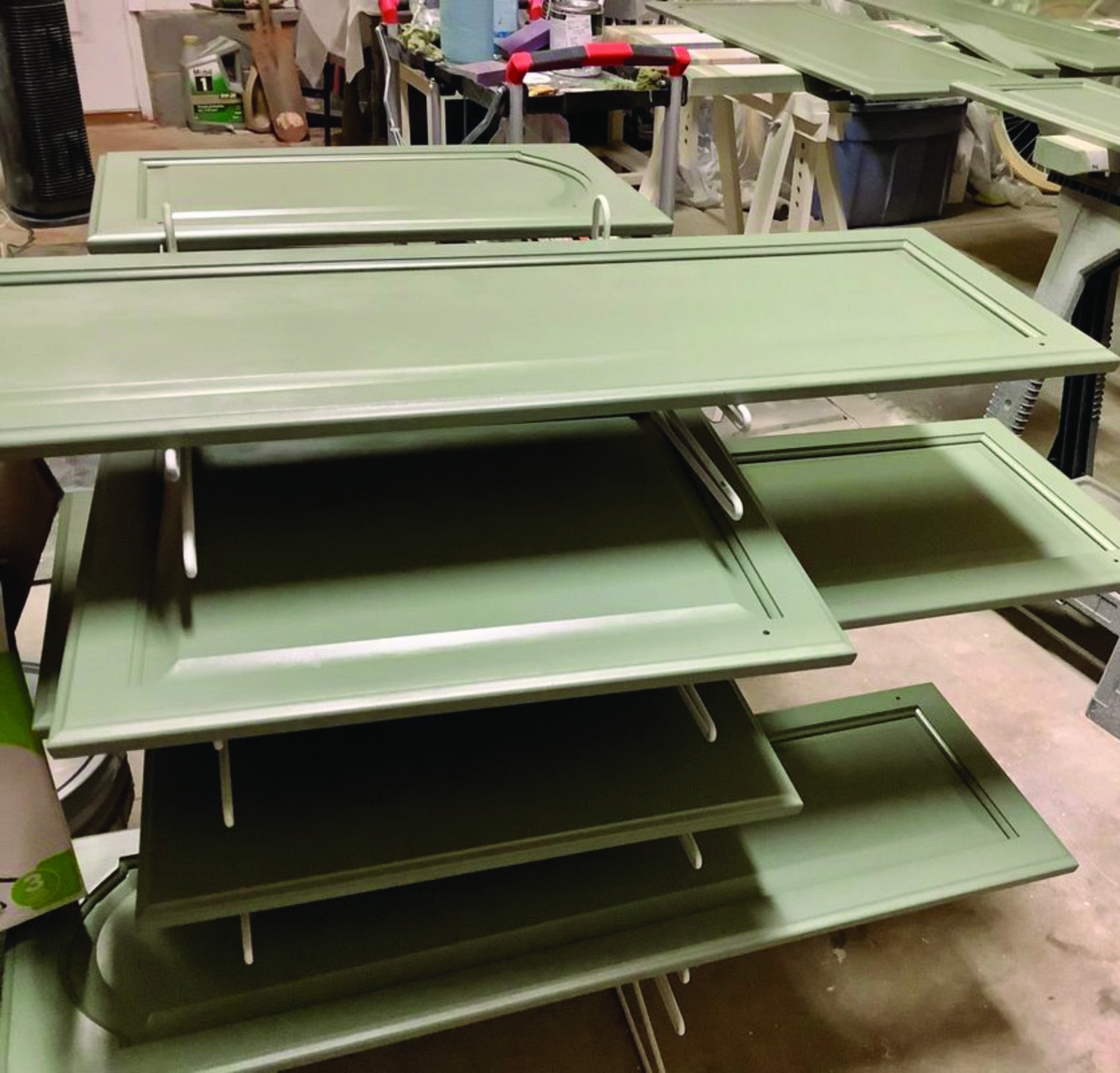 A bunch of green cabinet doors are stacked on top of each other