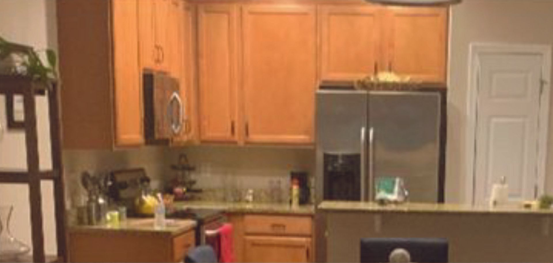 A kitchen with wooden cabinets and a stainless steel refrigerator