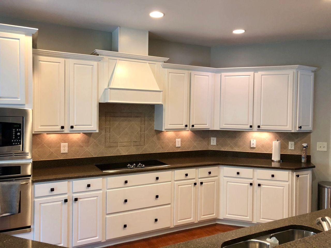 A kitchen with white cabinets and granite counter tops