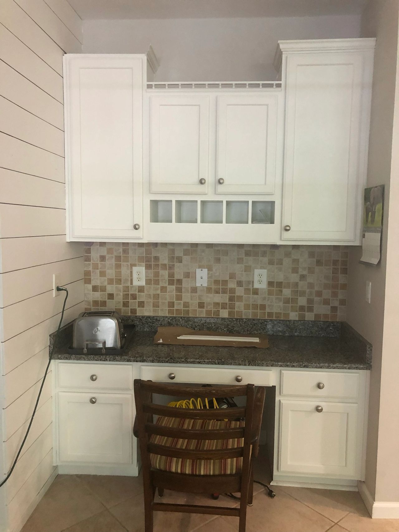 A kitchen with white cabinets and granite counter tops