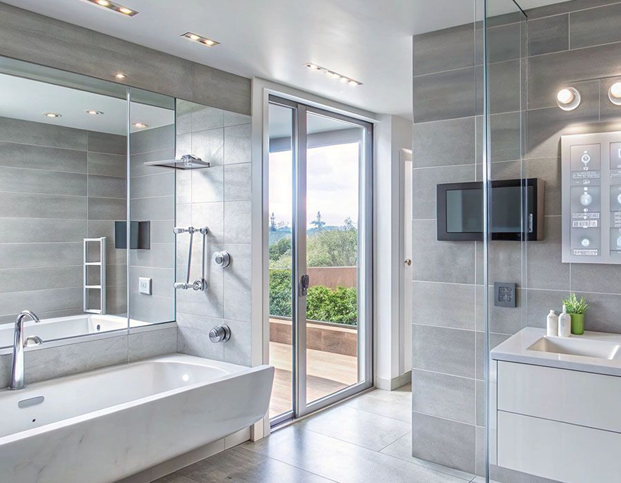 Modern gray bathroom with a freestanding tub, glass shower, vanity, and open balcony doors.