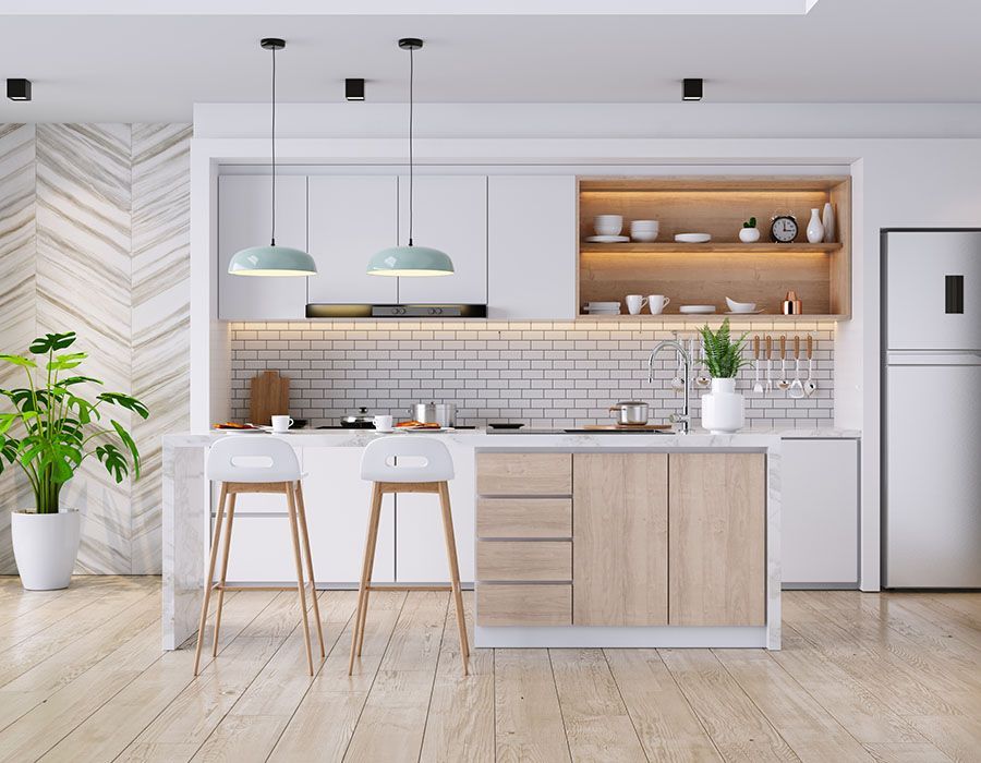 Bright modern kitchen with island, white cabinets, pendant lights, and light wood floors