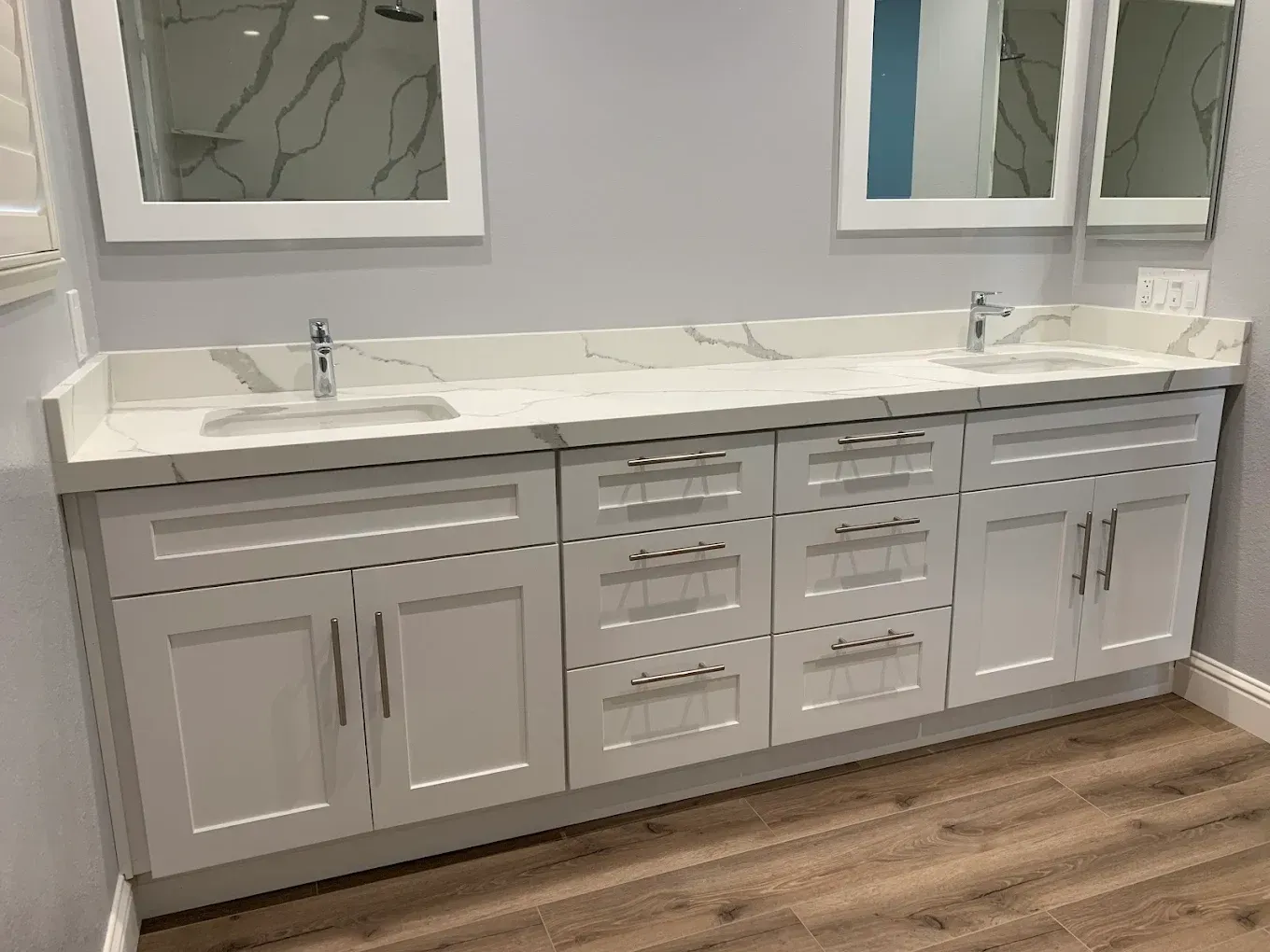 Modern bathroom vanity with double sinks, gray cabinets, and wood-look flooring