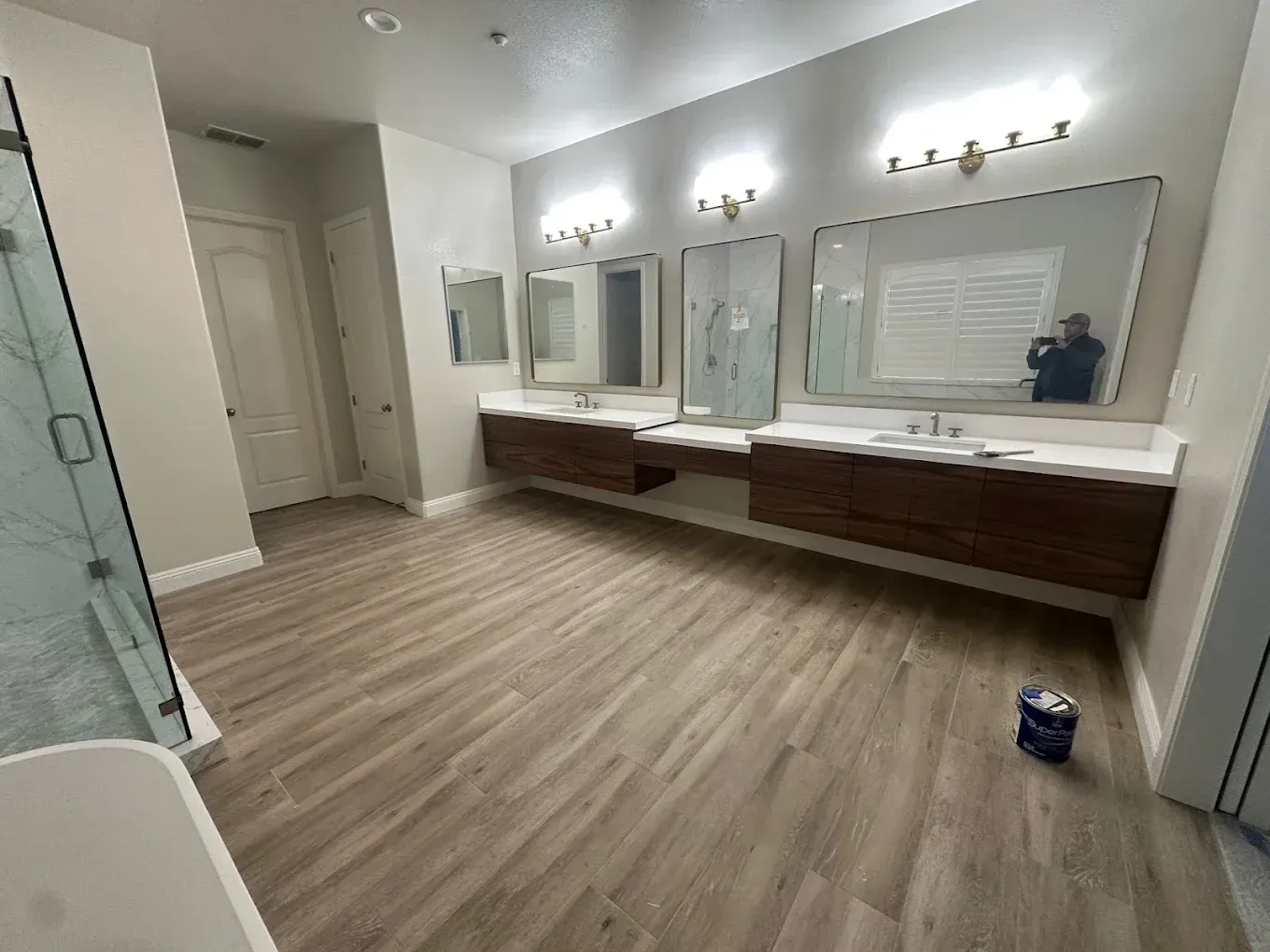 Empty dressing room with mirrors, wall lights, and wooden counters.
