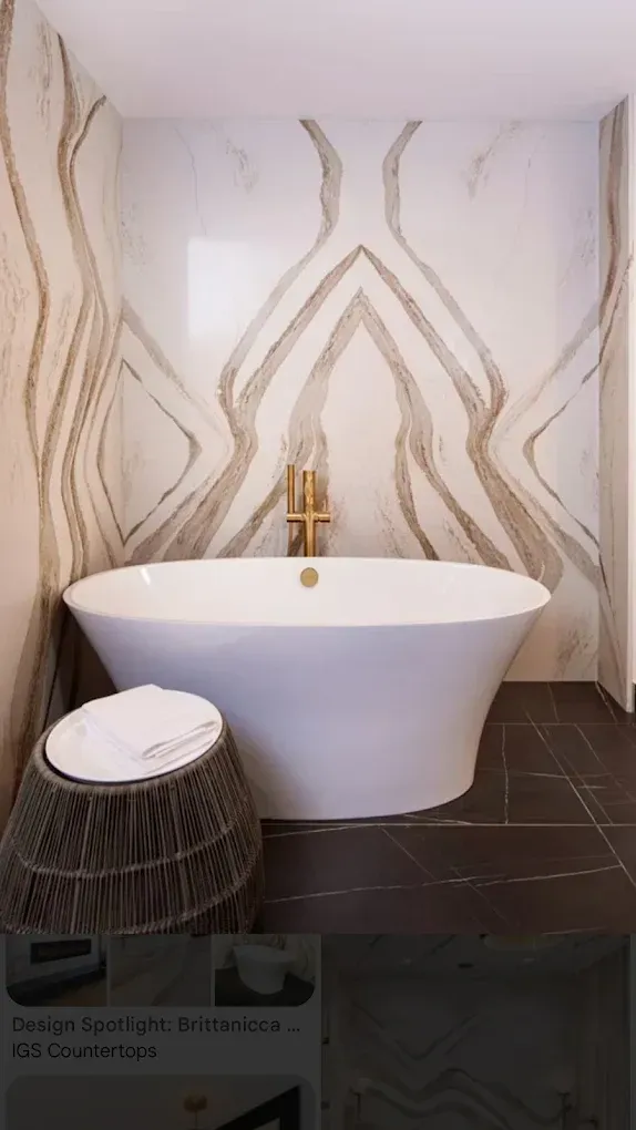 Luxury bathroom with a white freestanding tub, gold faucet, and marble-patterned wall art.