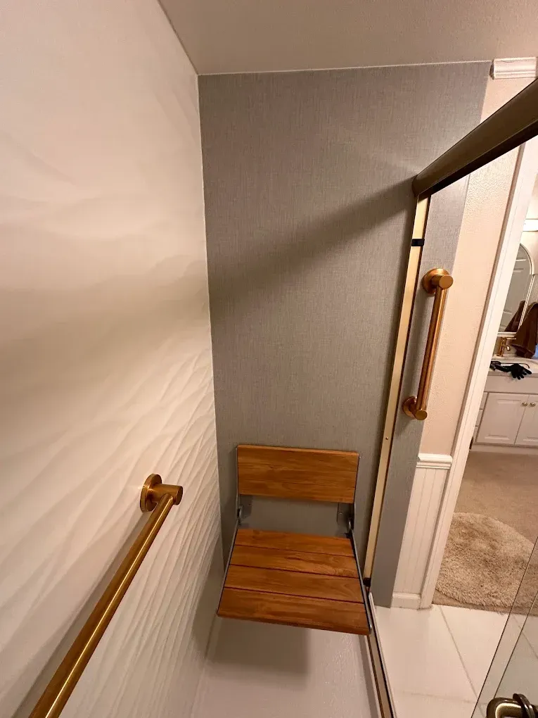 Stairwell with wooden handrails and a wooden chair on a small landing beside a doorway.
