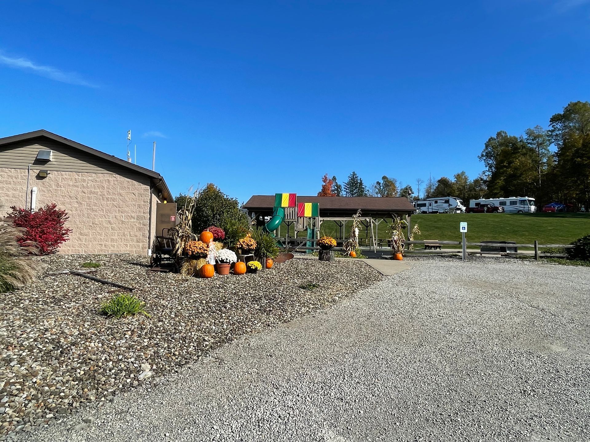Autumn scene: Pumpkins and gourds decorate a building's entrance; blue sky above.