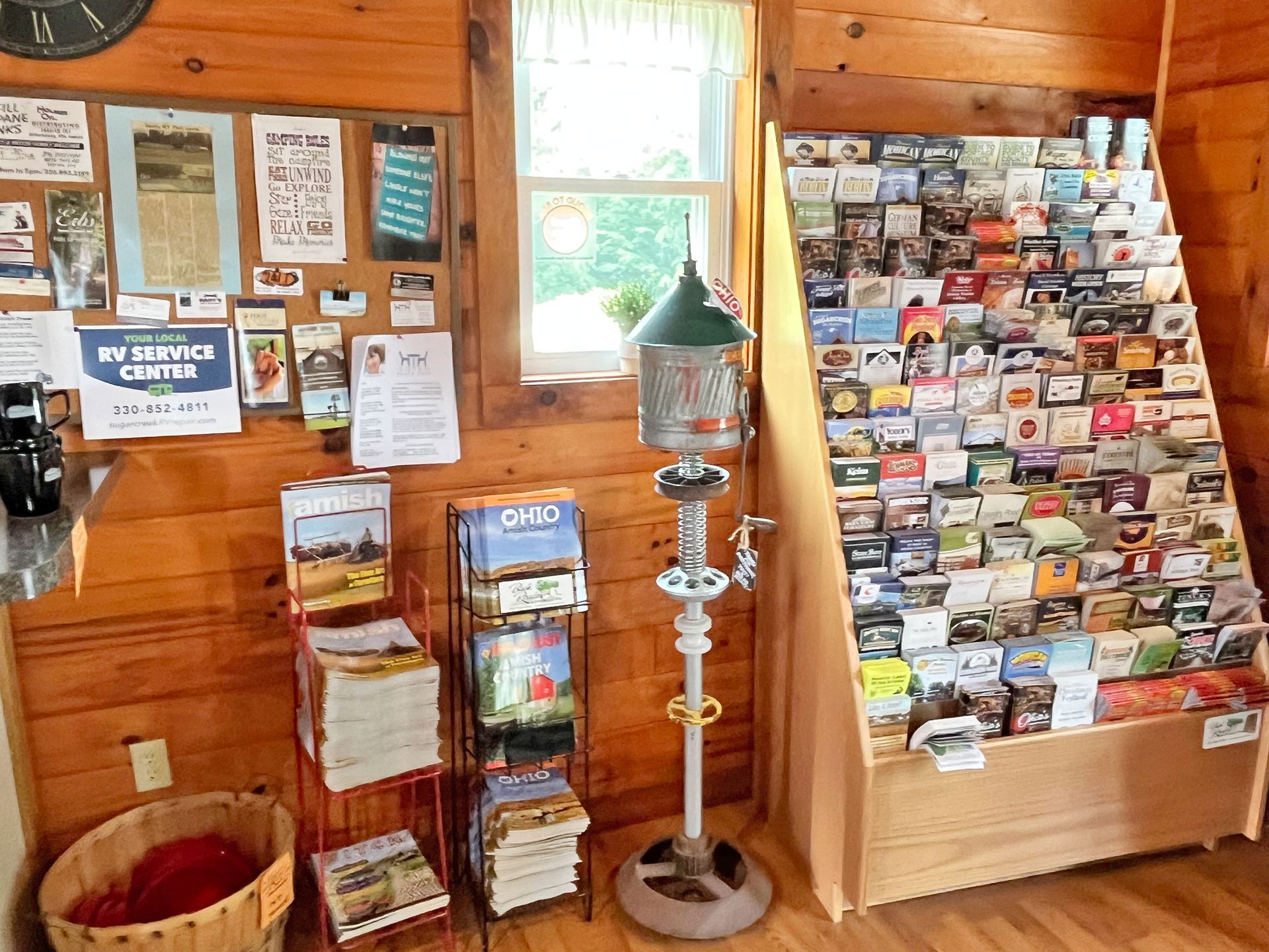 Interior with brochures, information, and a vintage water pump in a wooden-paneled building.