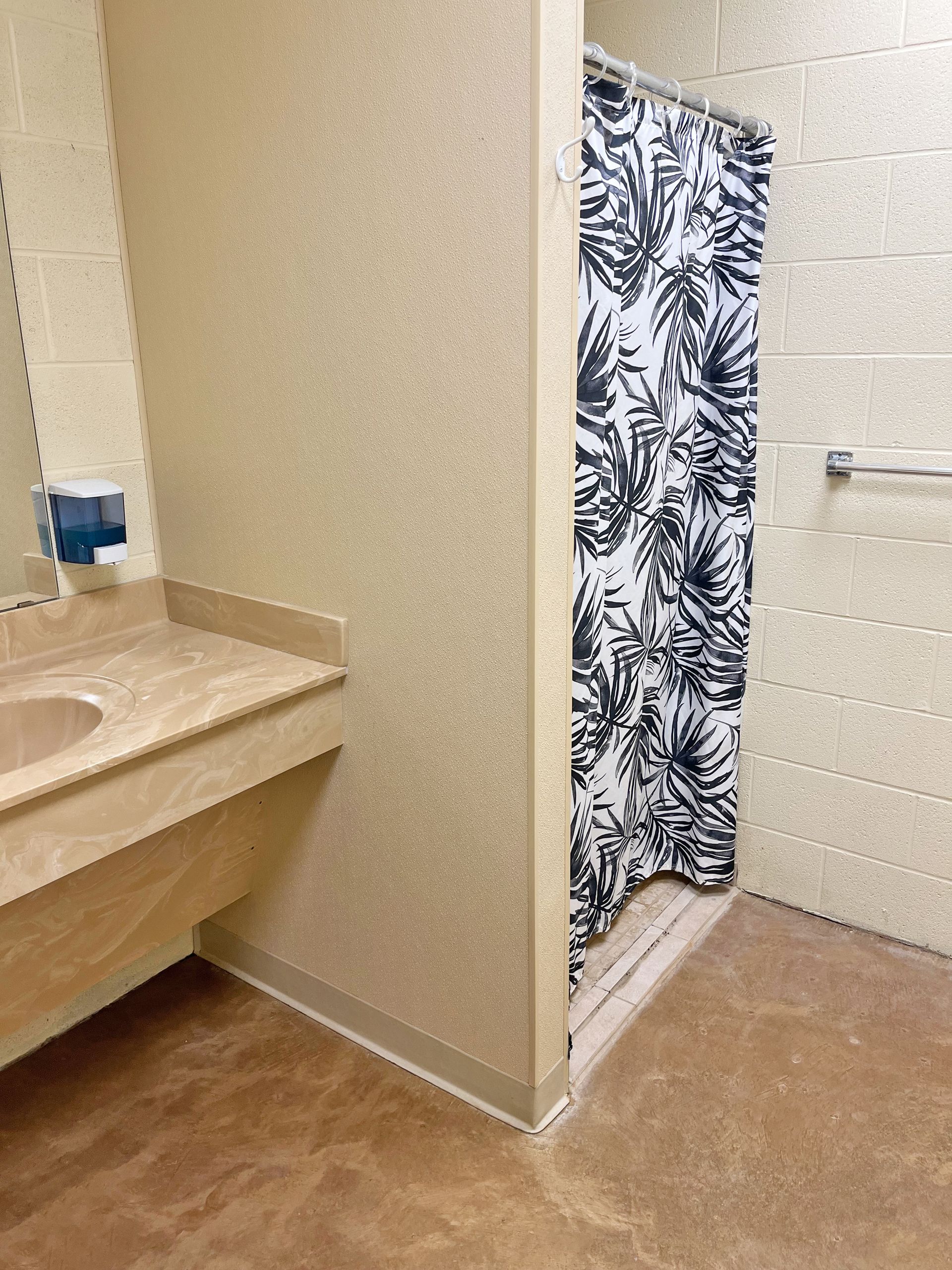 Bathroom interior with shower stall, sink, and textured walls.