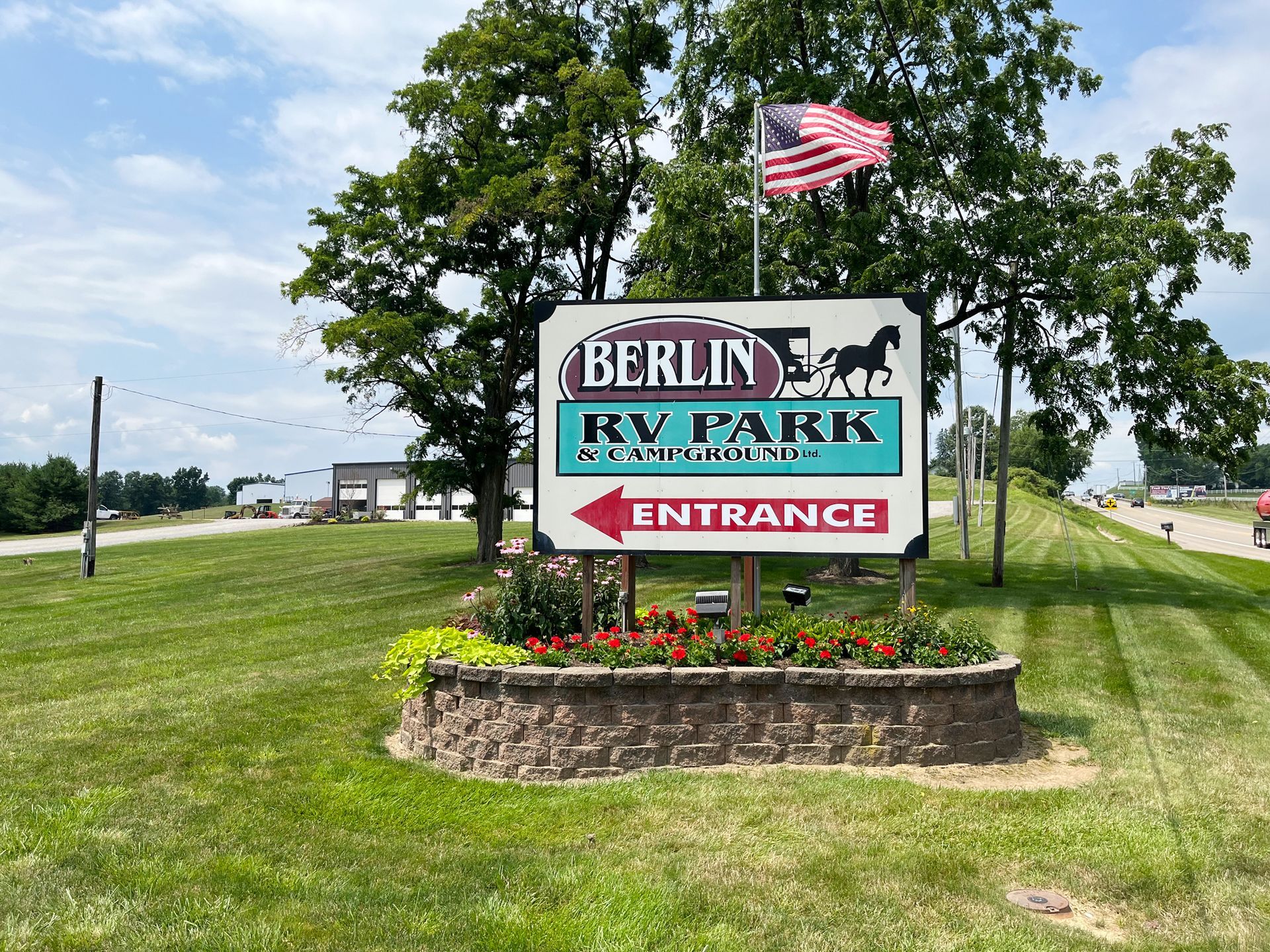 Sign for Berlin RV Park with an American flag.