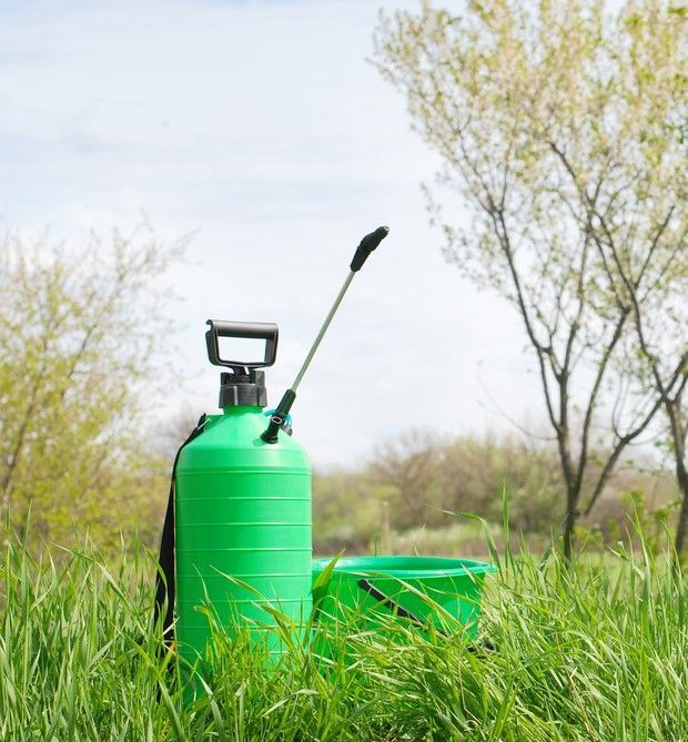 A Green Sprayer Is Sitting in The Grass in A Field — Yeppoon Stockfeed & Rural Supplies in Yeppoon, QLD
