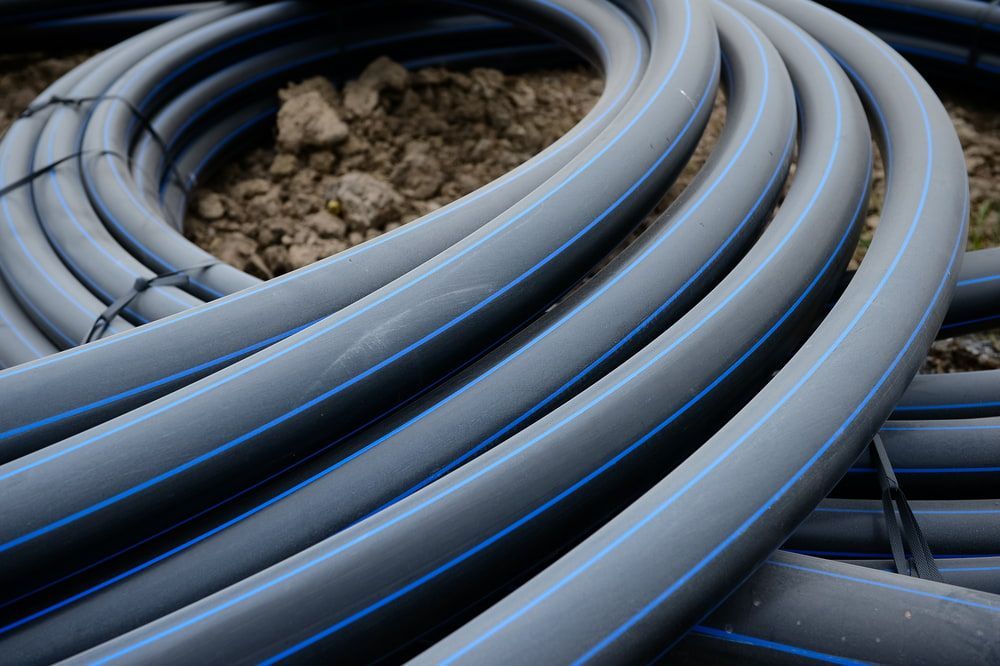 A Bunch of Plastic Pipes Are Stacked on Top of Each Other on The Ground — Yeppoon Stockfeed & Rural Supplies in Yeppoon, QLD