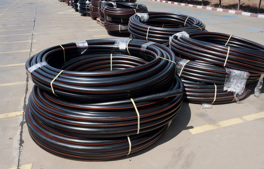 Several Rolls of Black Hose Are Stacked on Top of Each Other — Yeppoon Stockfeed & Rural Supplies in Yeppoon, QLD