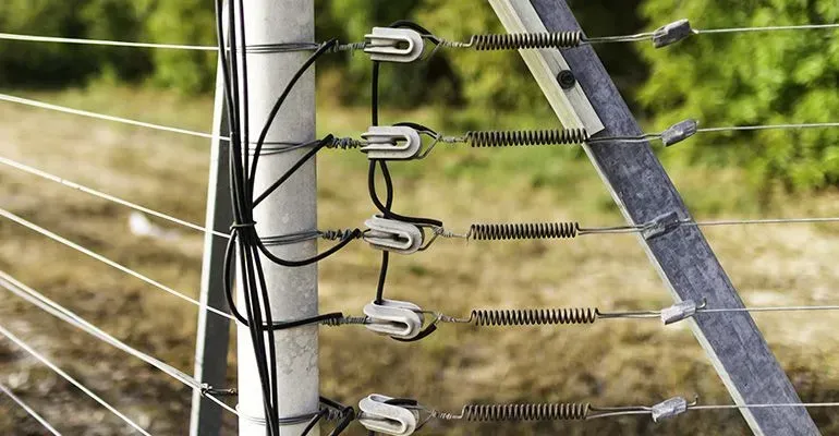 A Close up Of a Barbed Wire Fence with Trees in The Background — Yeppoon Stockfeed & Rural Supplies in Yeppoon, QLD