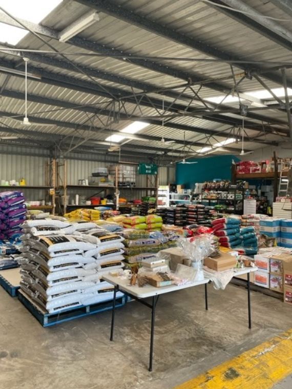 A Warehouse Filled with Lots of Bags of Food and Tables — Yeppoon Stockfeed & Rural Supplies in Yeppoon, QLD