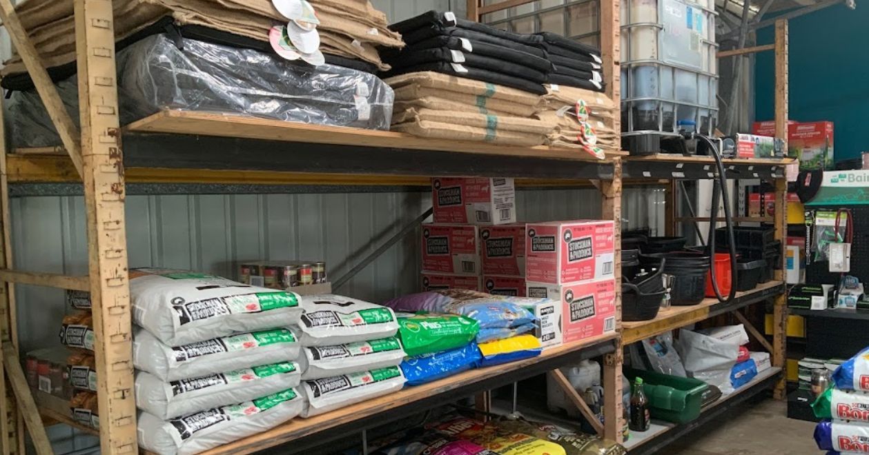 A Warehouse Filled with Shelves Filled with Bags of Fertilizer — Yeppoon Stockfeed & Rural Supplies in Yeppoon, QLD