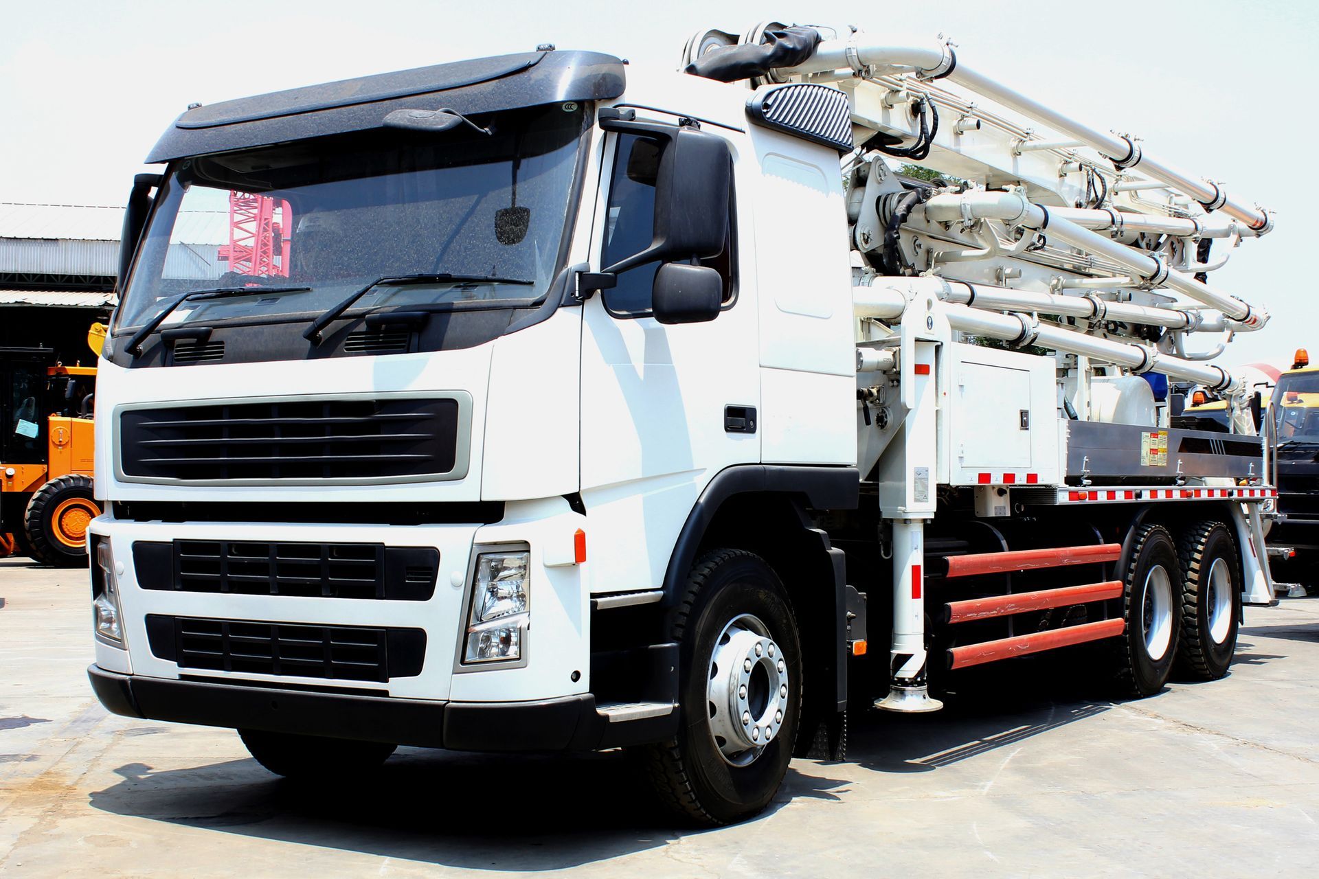 Concrete pump truck with multi-section boom mounted on the rear.
