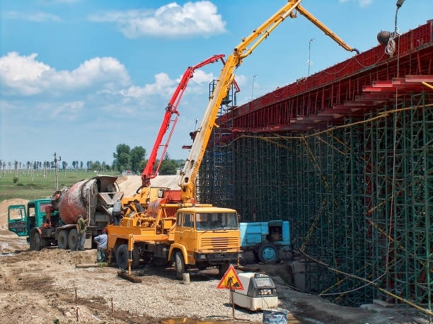 A concrete pump is being used to pour concrete on a bridge under construction.