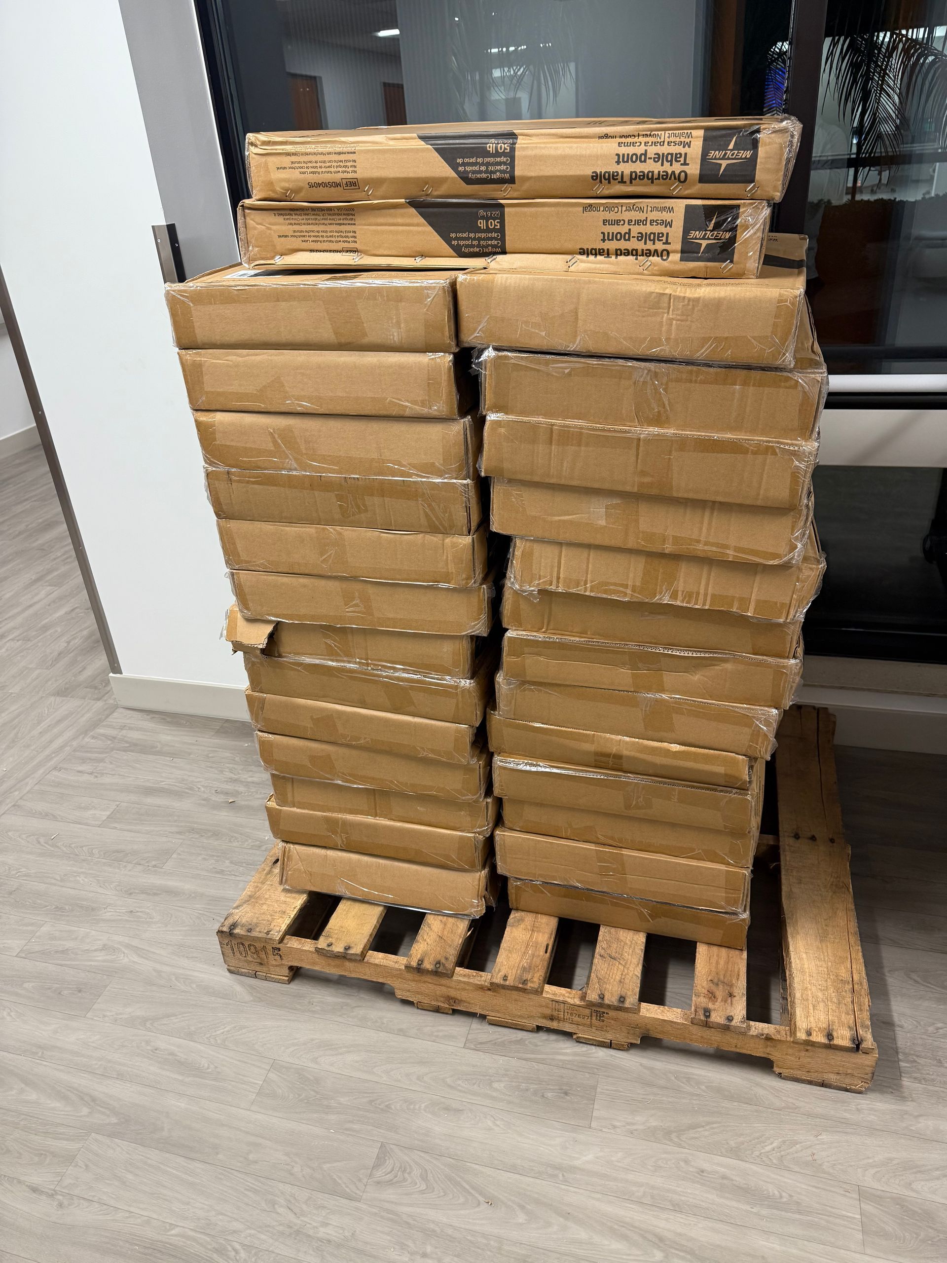 Stacked cardboard boxes on a wooden pallet in a warehouse aisle