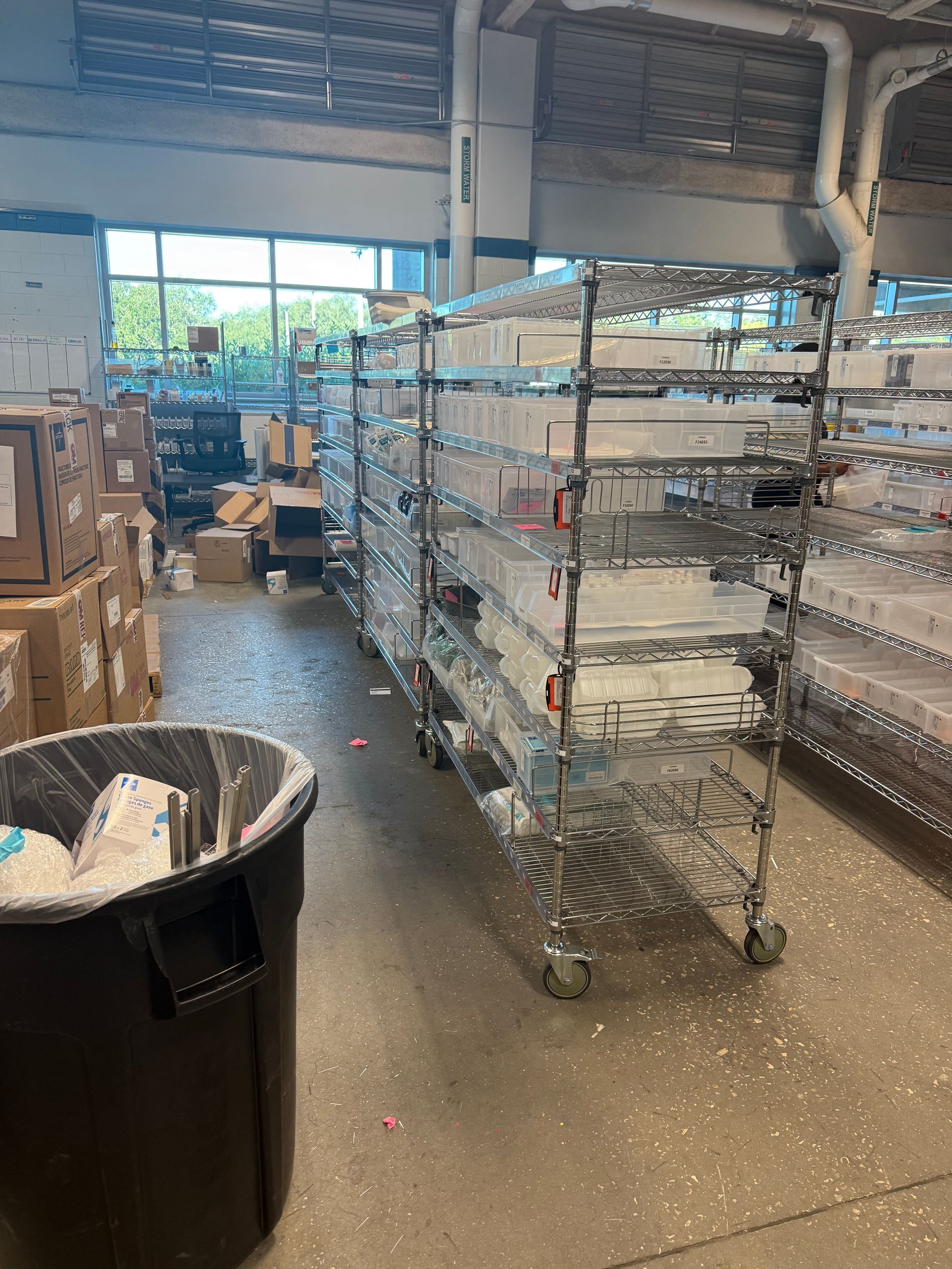 Store aisle with metal carts, shelves, and a trash bin in a warehouse-like retail space