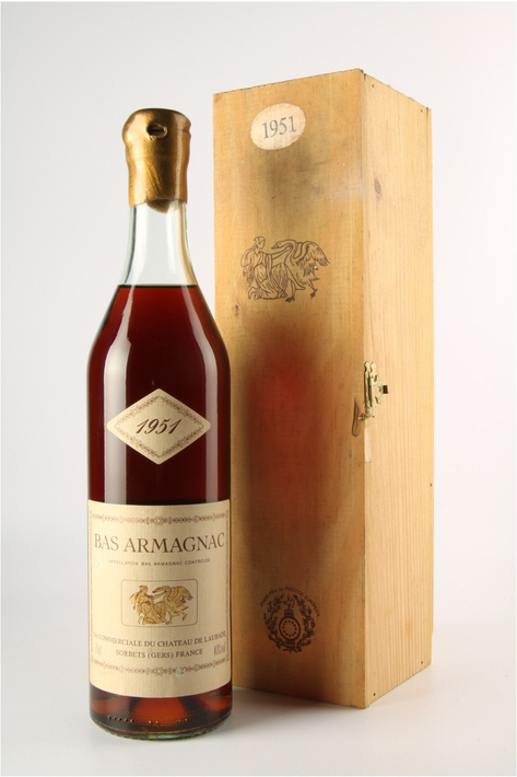 Bottle of 1957 vintage Armagnac with a wooden box. The liquid is amber, label reads