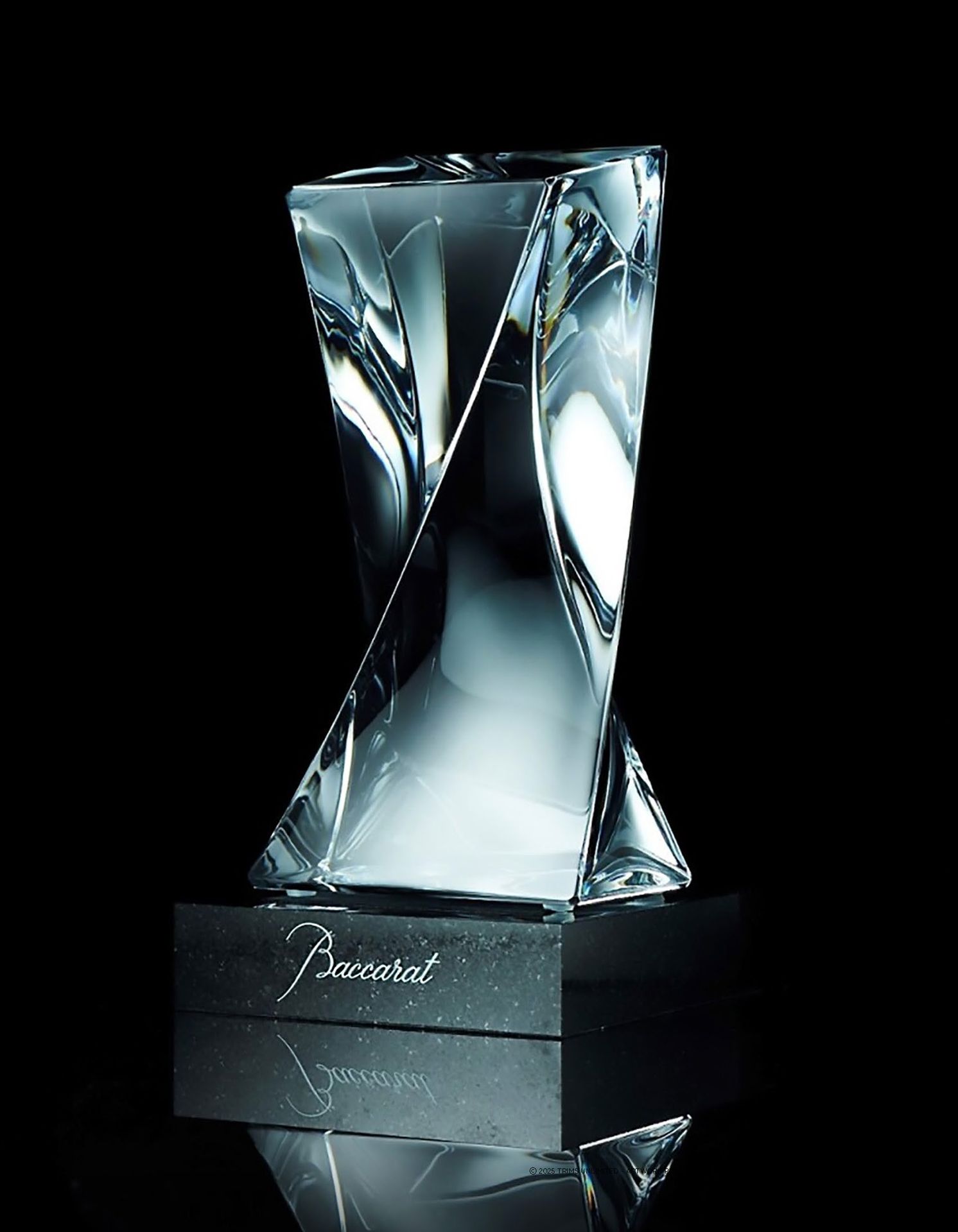 Twisted crystal vase on a black base, reflective surface,