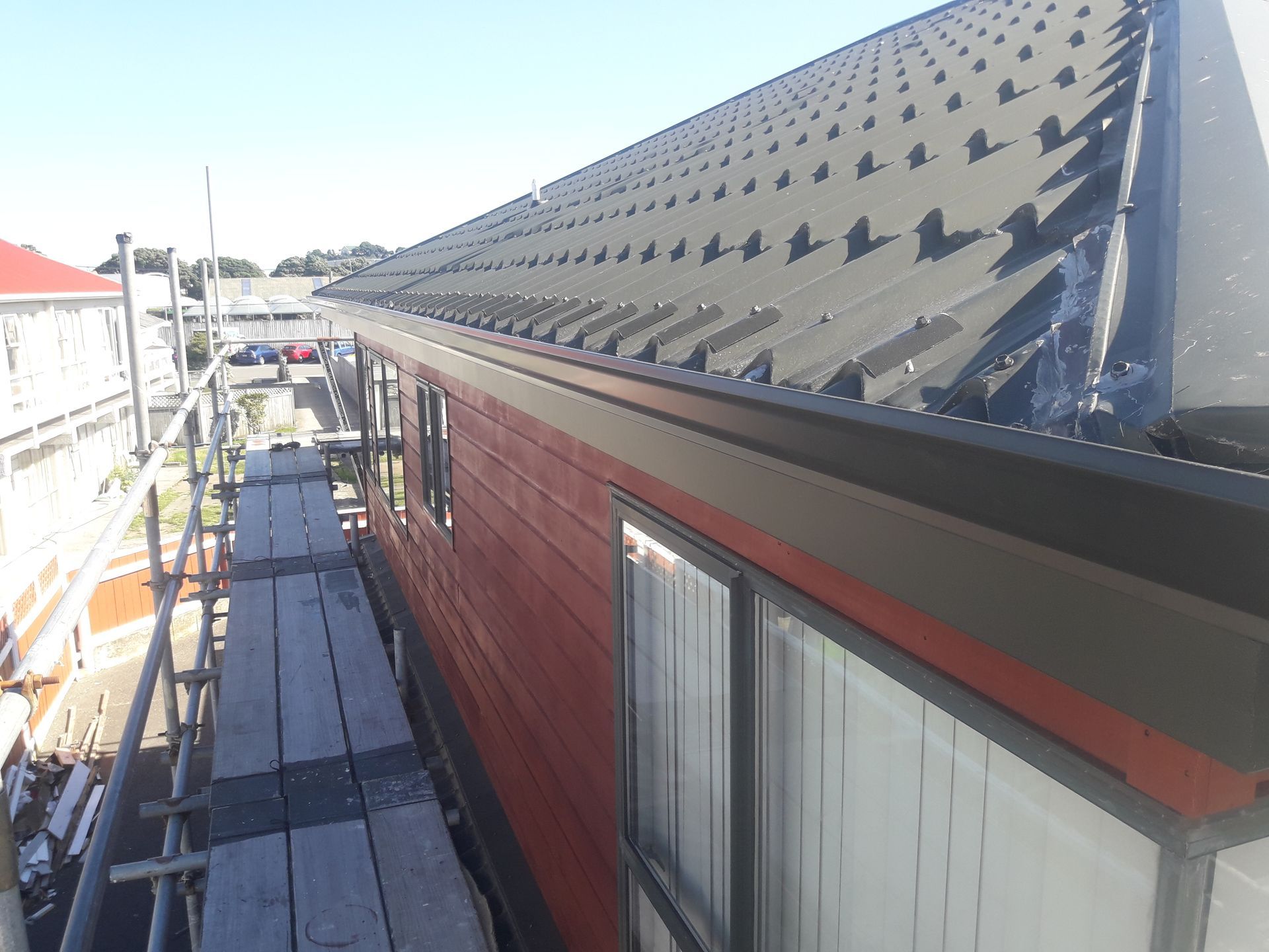 Rows of copper roof tiles with water streaming along the edge