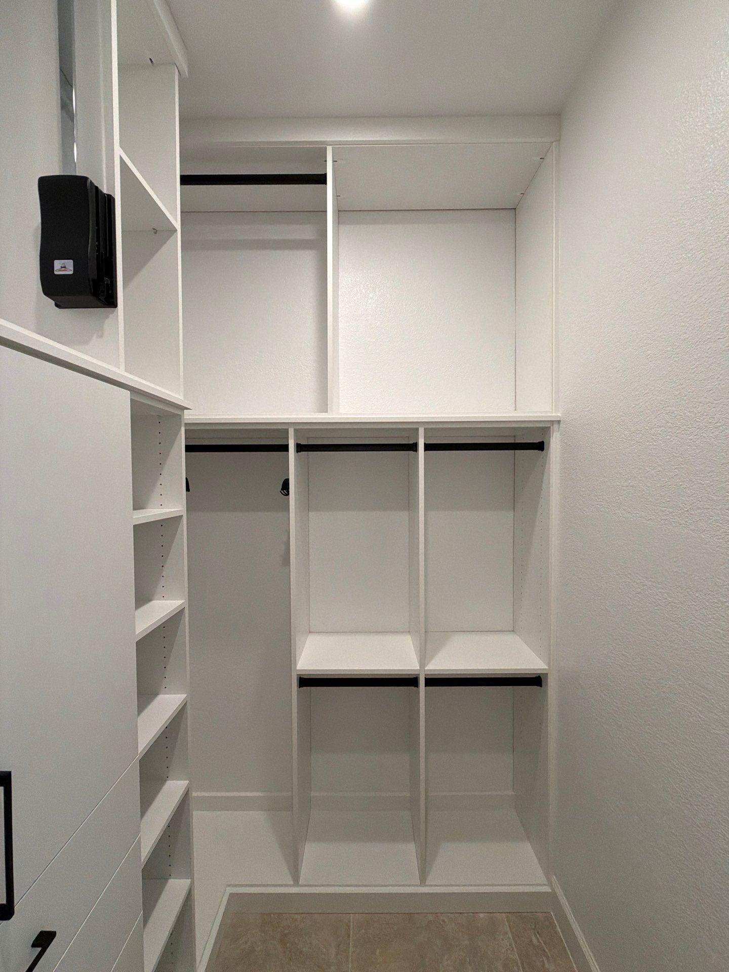 White walk-in closet with shelves, hanging rods, and built-in cubbies.