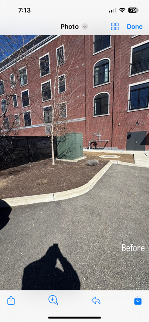 A person is taking a picture of a brick building with their phone.