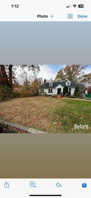 A picture of a house with a lot of leaves on the ground.