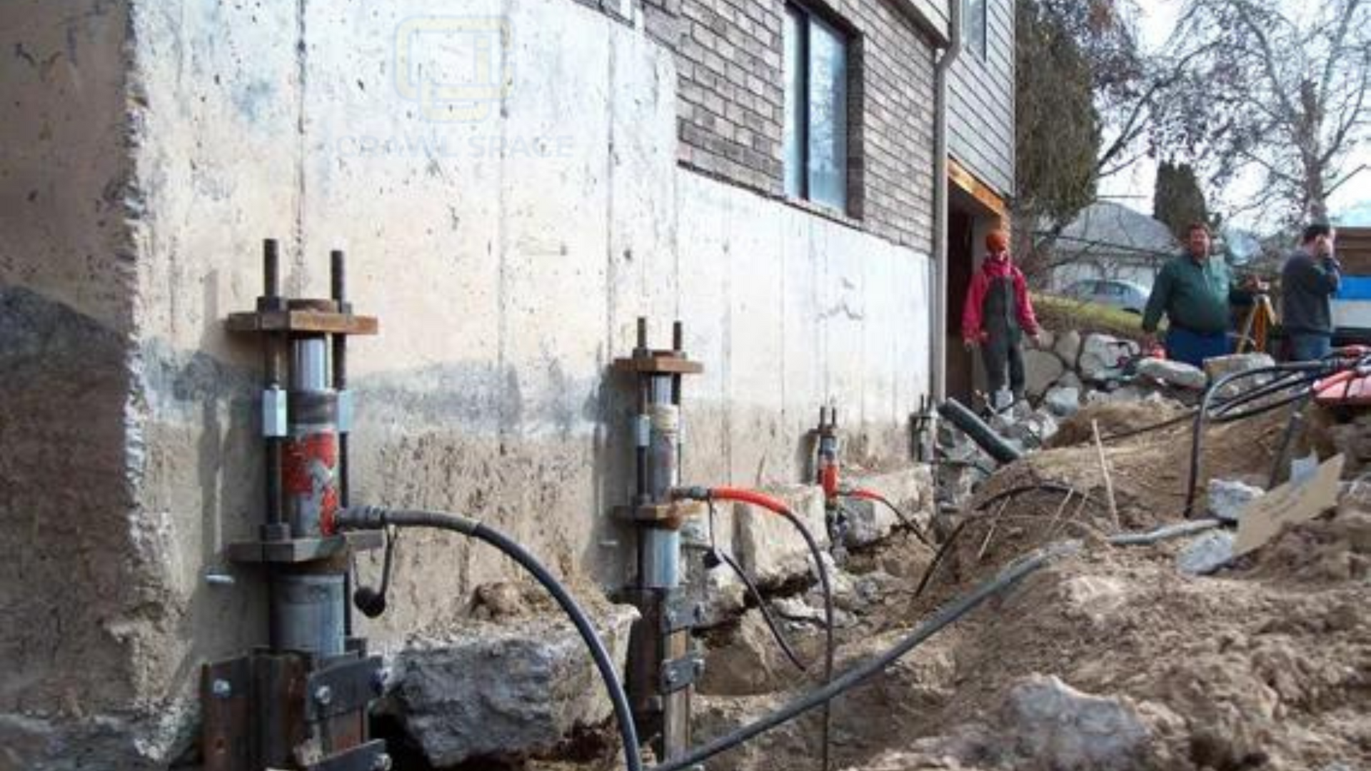 A group of people are working on the foundation of a house.