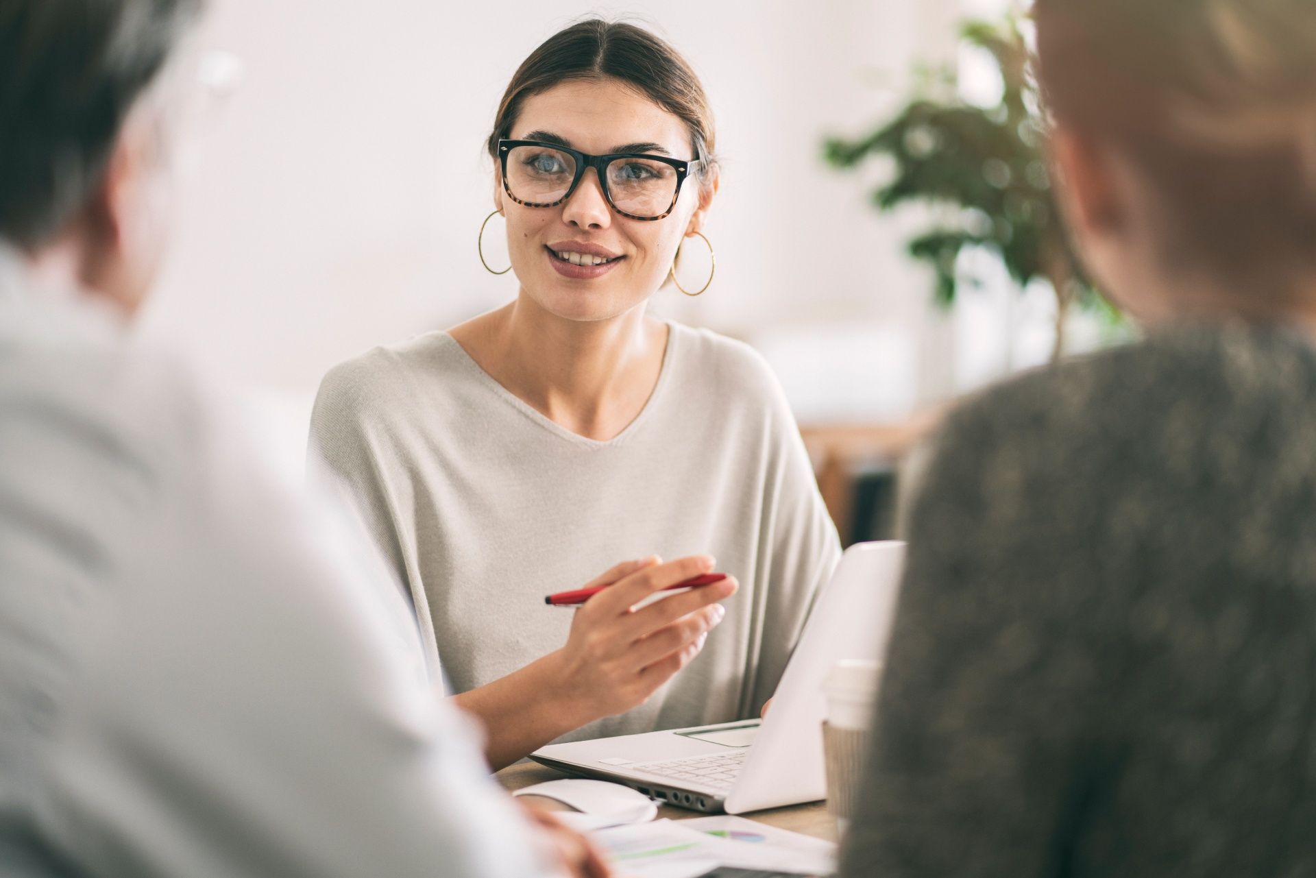 A woman is sitting at a table talking to a group of people.