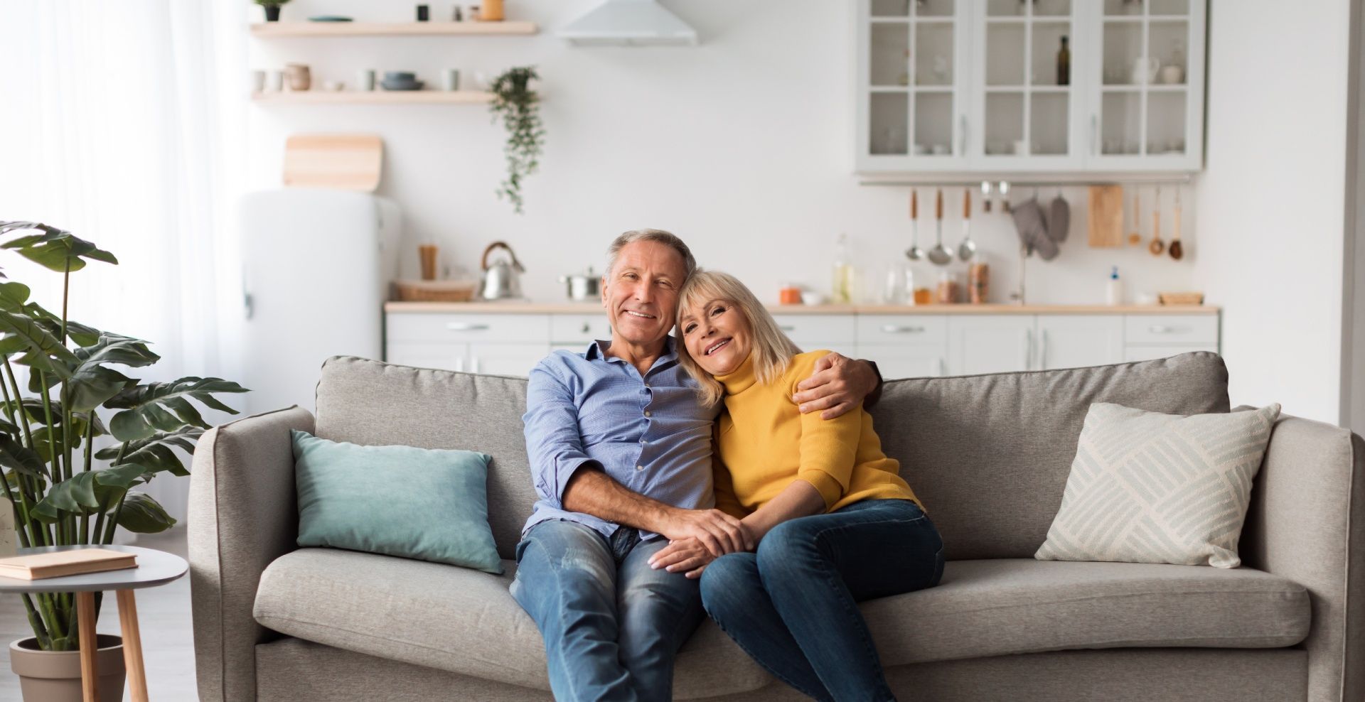 A man and a woman are sitting on a couch in a living room.