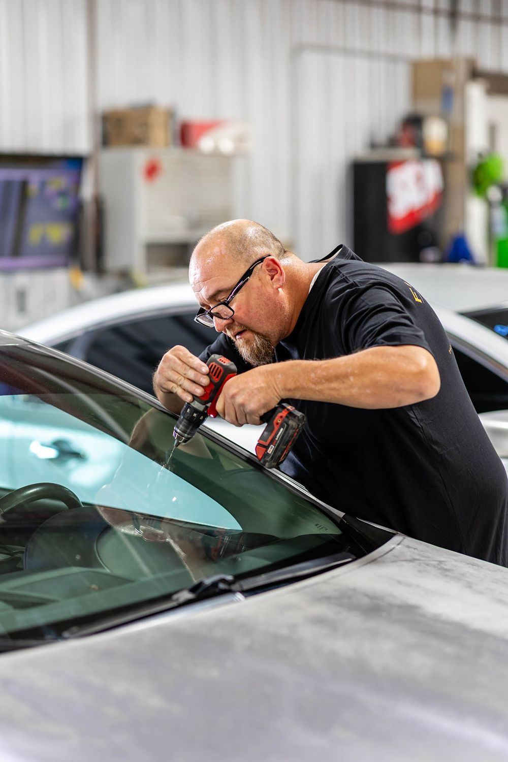 Mechanic polishing a car windshield in a workshop