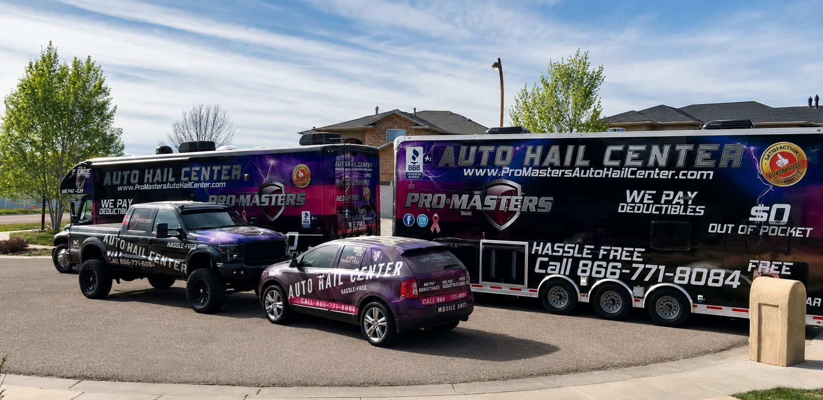 Auto hail center parking lot with three branded vehicles and large service sign.
