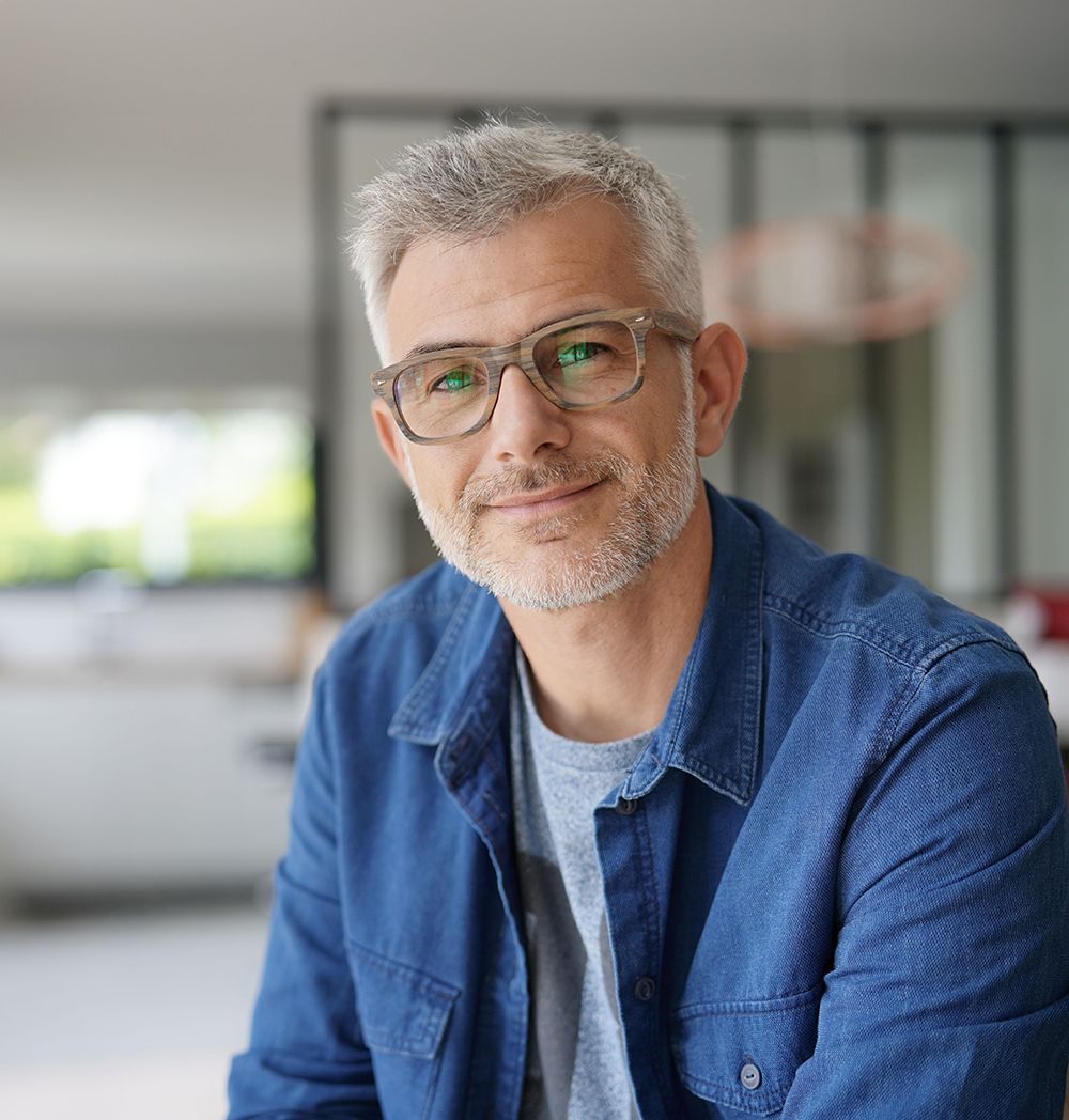 Middle aged man smiling wearing glasses