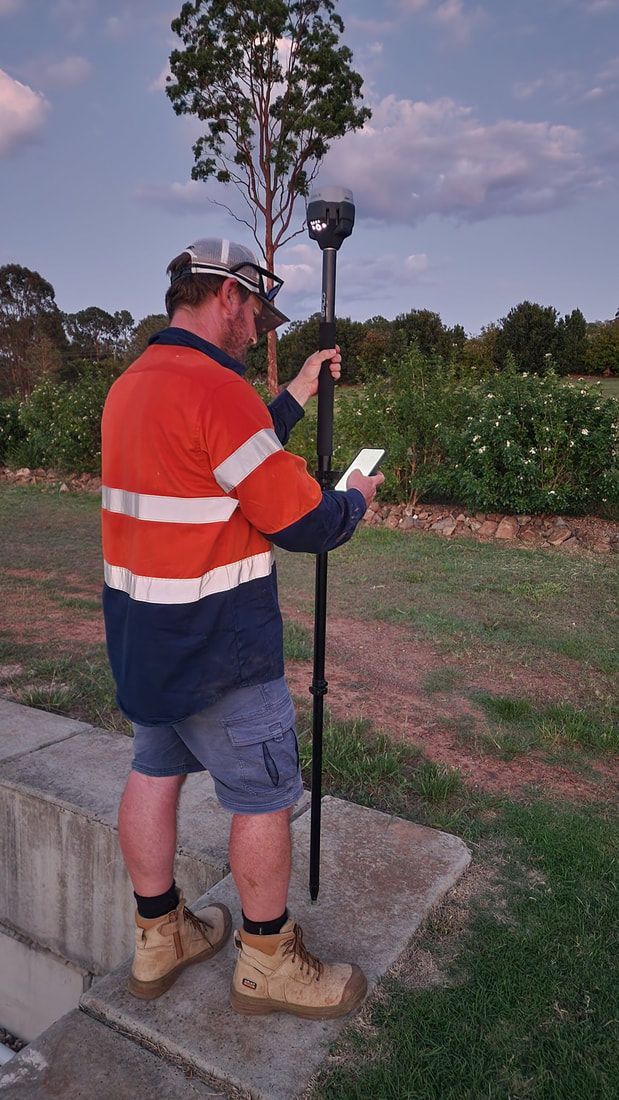 Man in Work Clothes Uses GPS Device, Outdoors — Found It Down Under in Glenwood, QLD