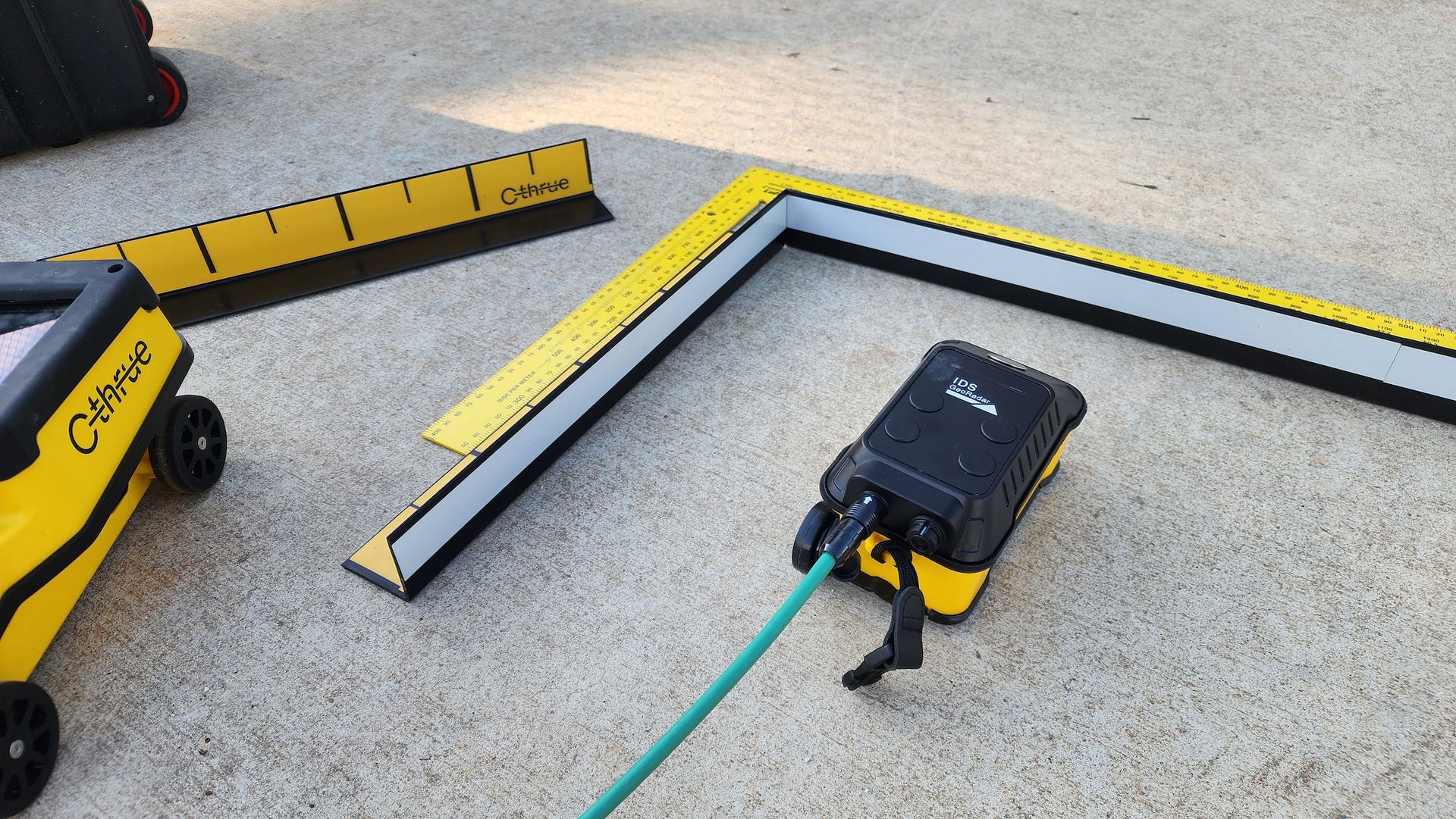 Yellow and Black Equipment With Measuring Guides and a Hose on Pavement — Found It Down Under in Fraser Coast, QLD