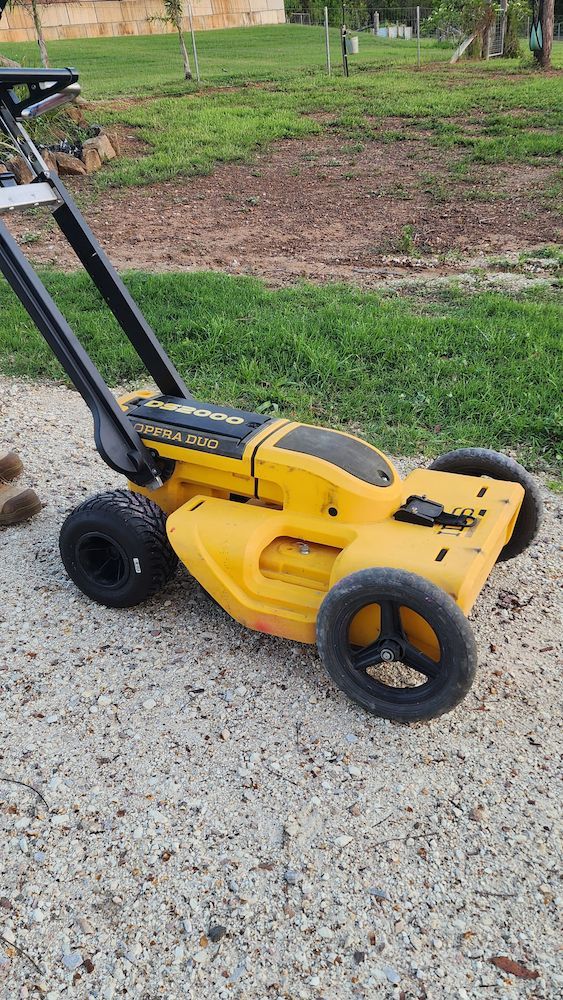 Yellow Push Lawn Mower on a Gravel Path Beside a Patchy Grassy Yard — Found It Down Under in Childers, QLD