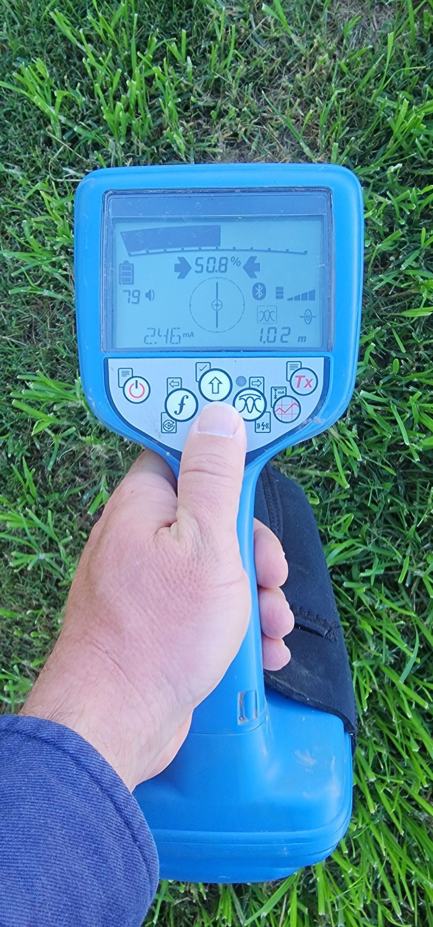 A Hand Holding a Blue Utility Locator on Green Grass — Found It Down Under in Glenwood, QLD