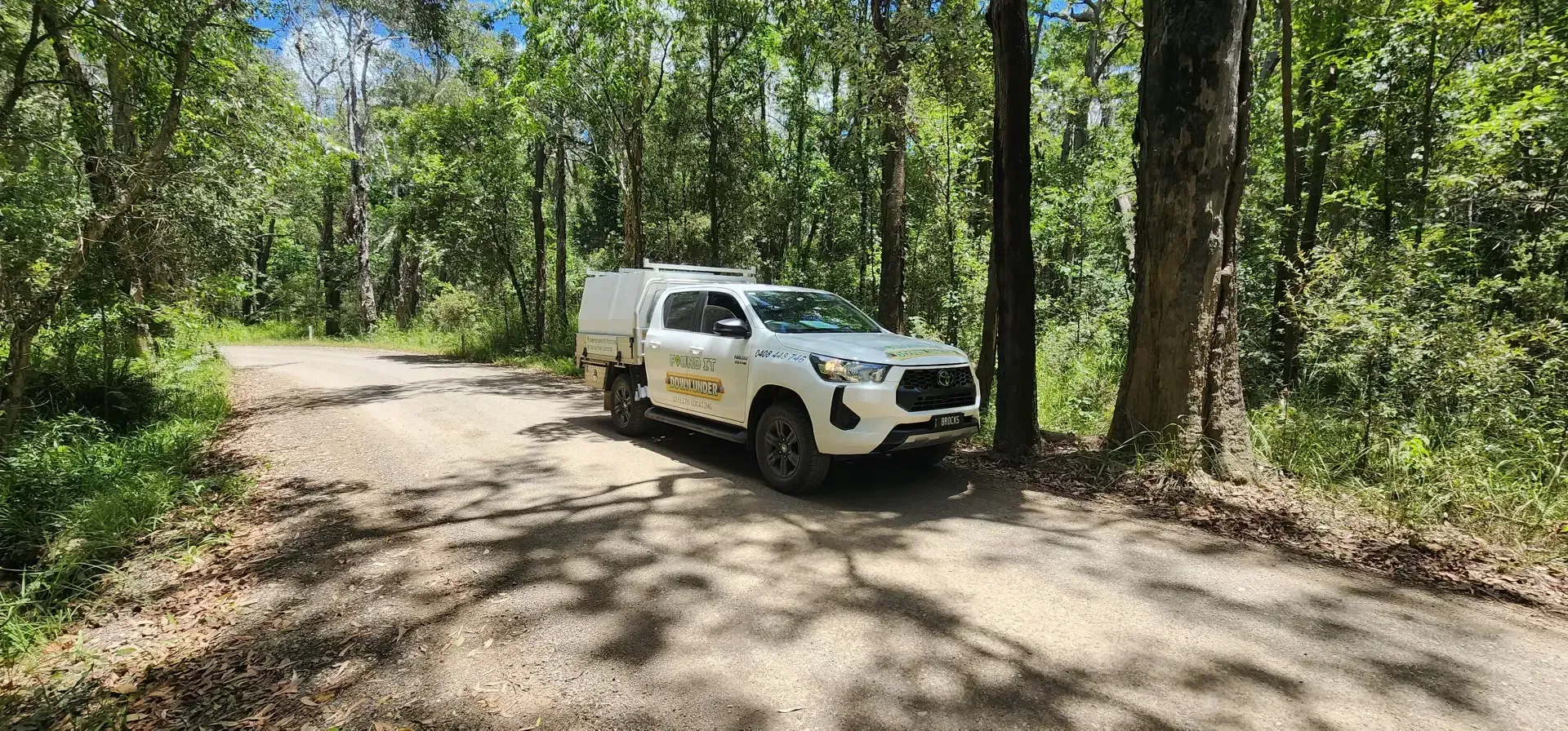 White Truck Parked on a Dirt Road in a Forest, Trees Surround the Vehicle — Found It Down Under in Widgee, QLD