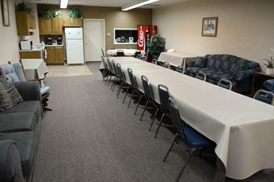 Conference room with long table, chairs, sofas, and a small kitchenette with a vending machine