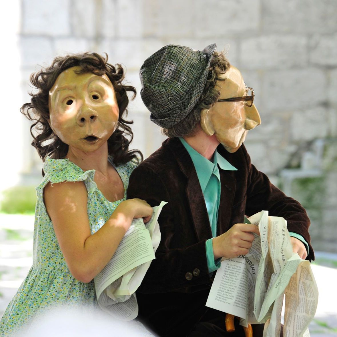 Ein Mann und eine Frau mit Masken halten Zeitungen