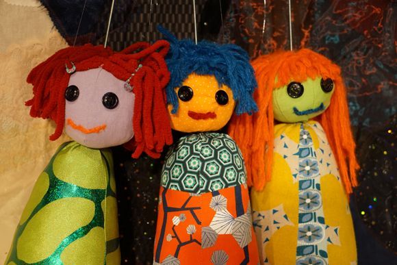 Drei Stoffpuppen mit verschiedenfarbigen Haaren und Gesichtern