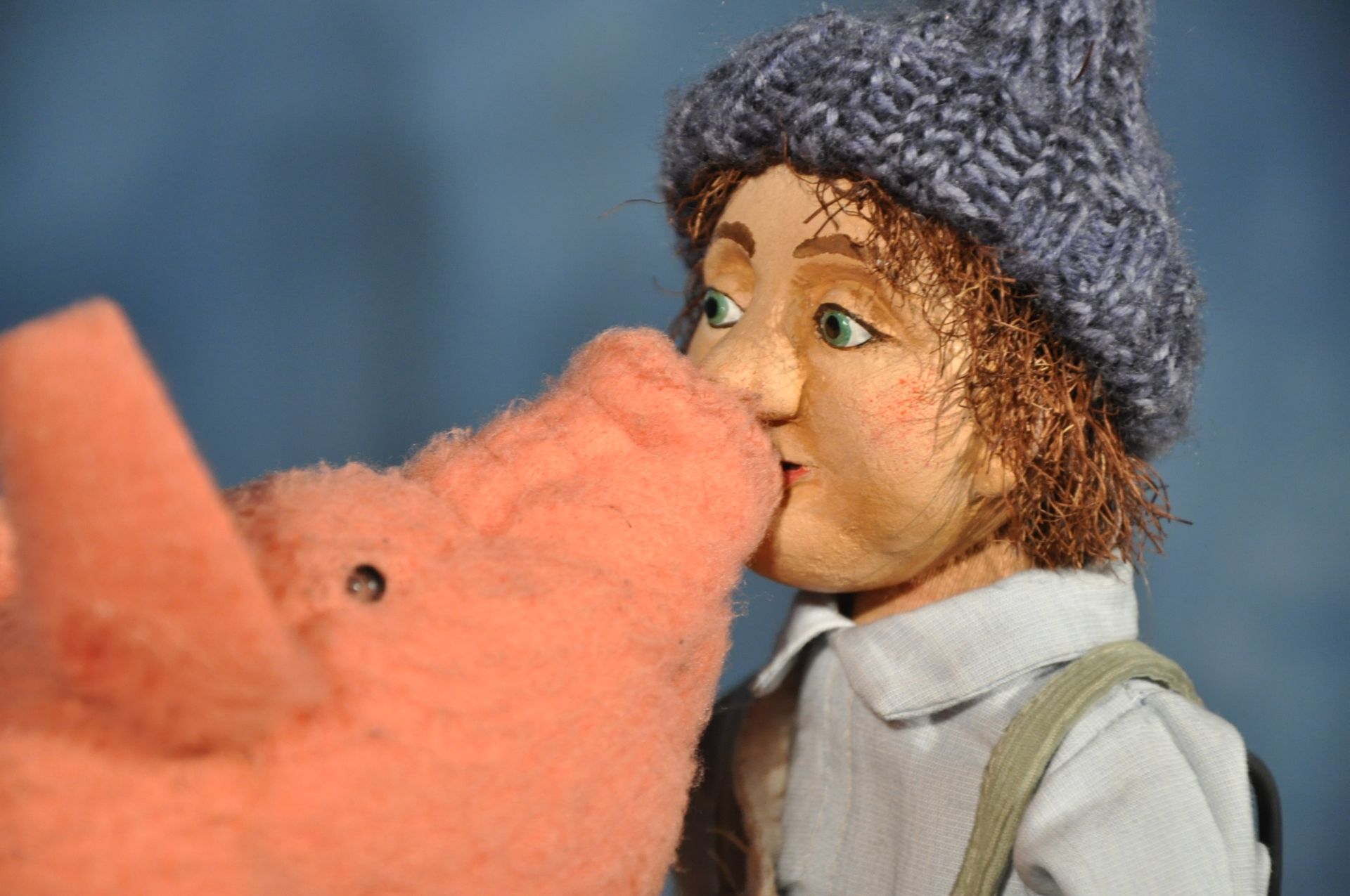 Eine Puppe küsst ein Stoffschwein auf die Nase