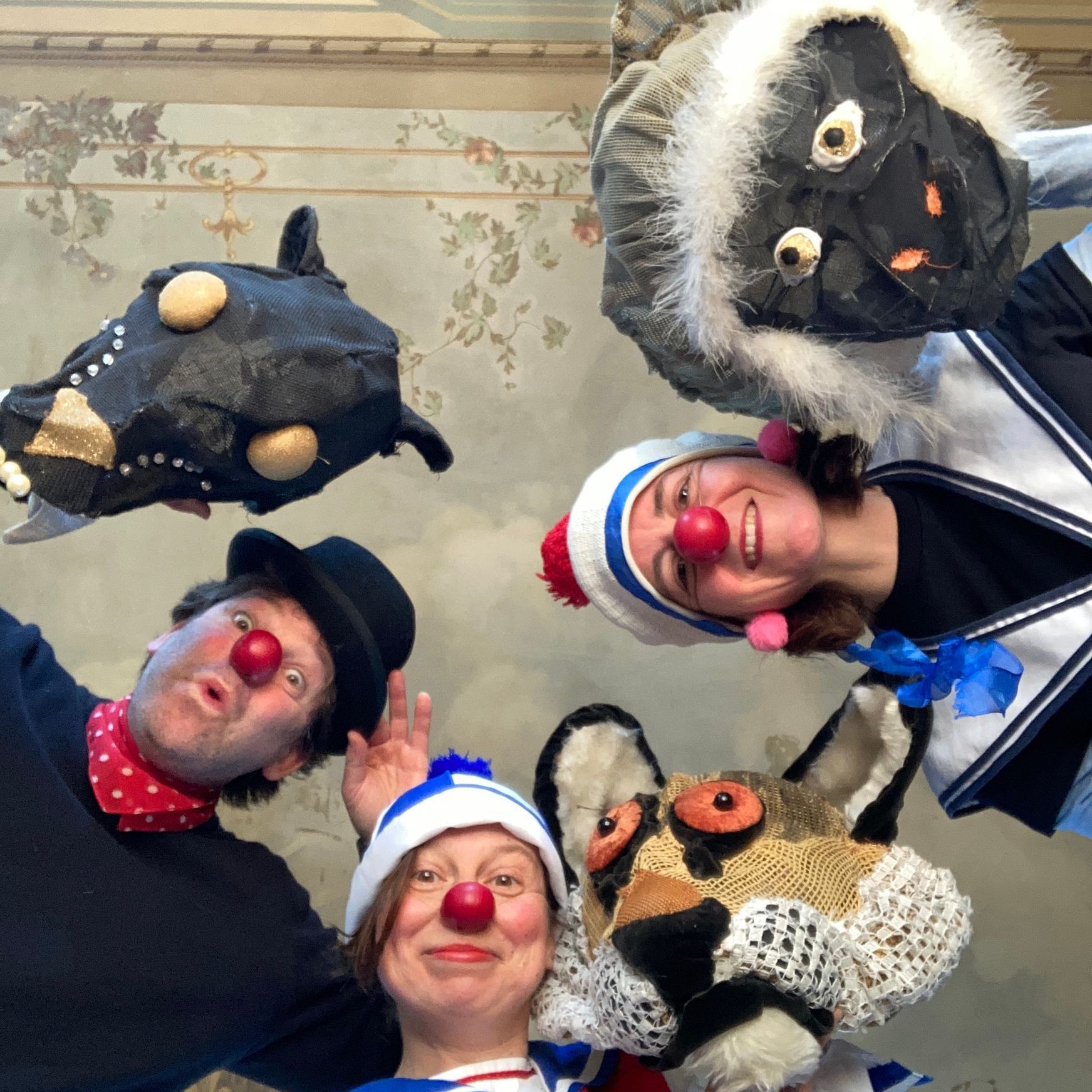 Eine Gruppe von Clowns posiert für ein Foto mit rot bemalten Gesichtern